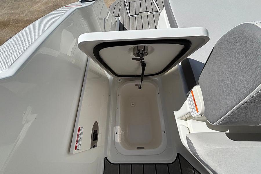2027 Sea Ray SDX 230 Outboard boat storage compartment with open lid and seating area.