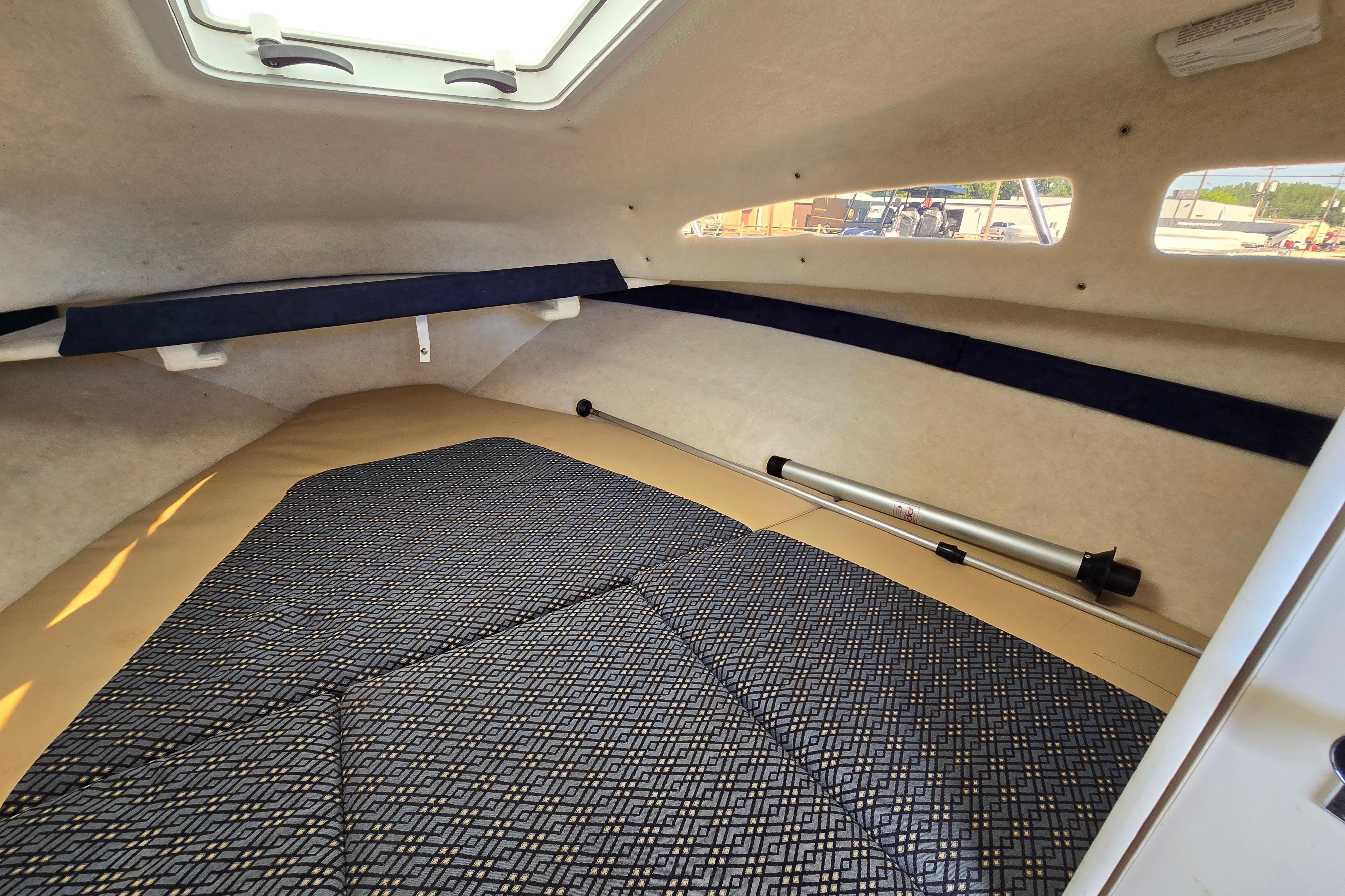 Interior cabin of 2006 Bayliner 222 Classic boat, featuring cushioned seating and windows.
