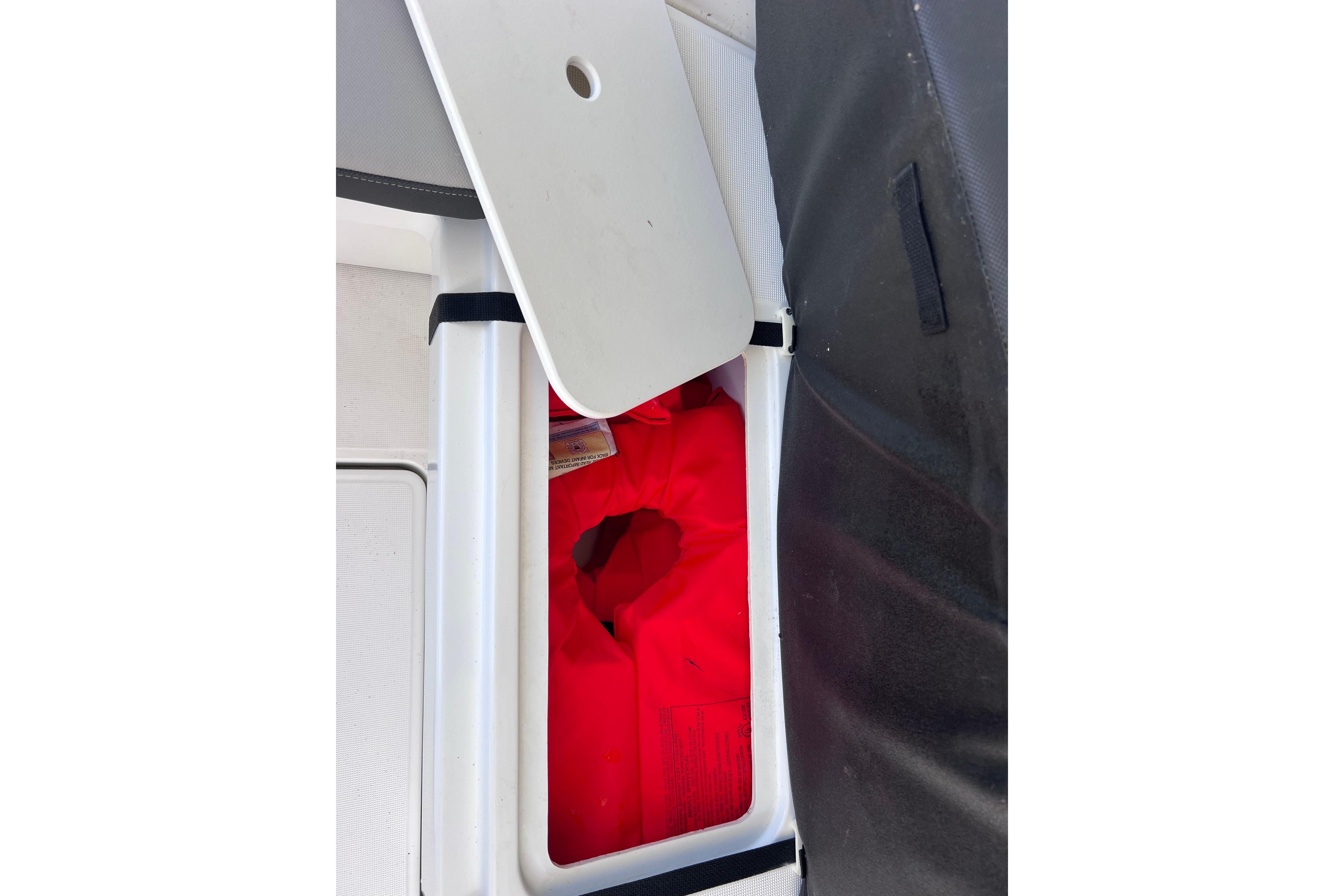 Storage compartment with red life jacket on Jeanneau NC Weekender 795 Series 2, 2021 model.