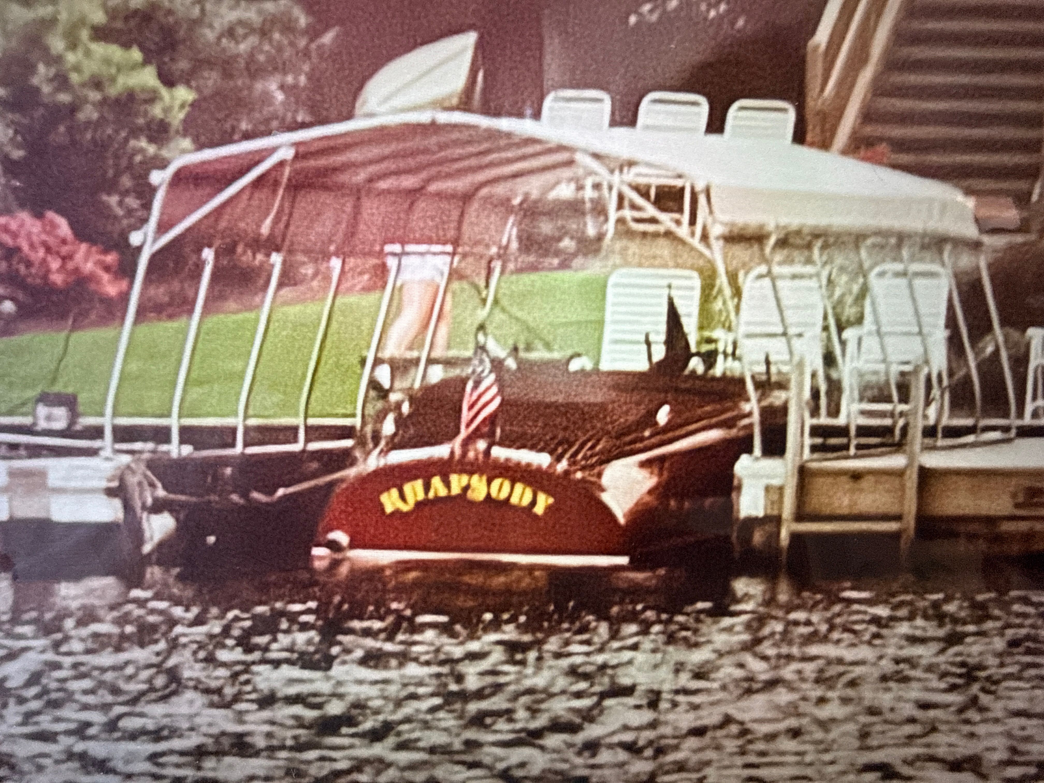1940 Chris-Craft Barrelback boat docked with covered seating area.