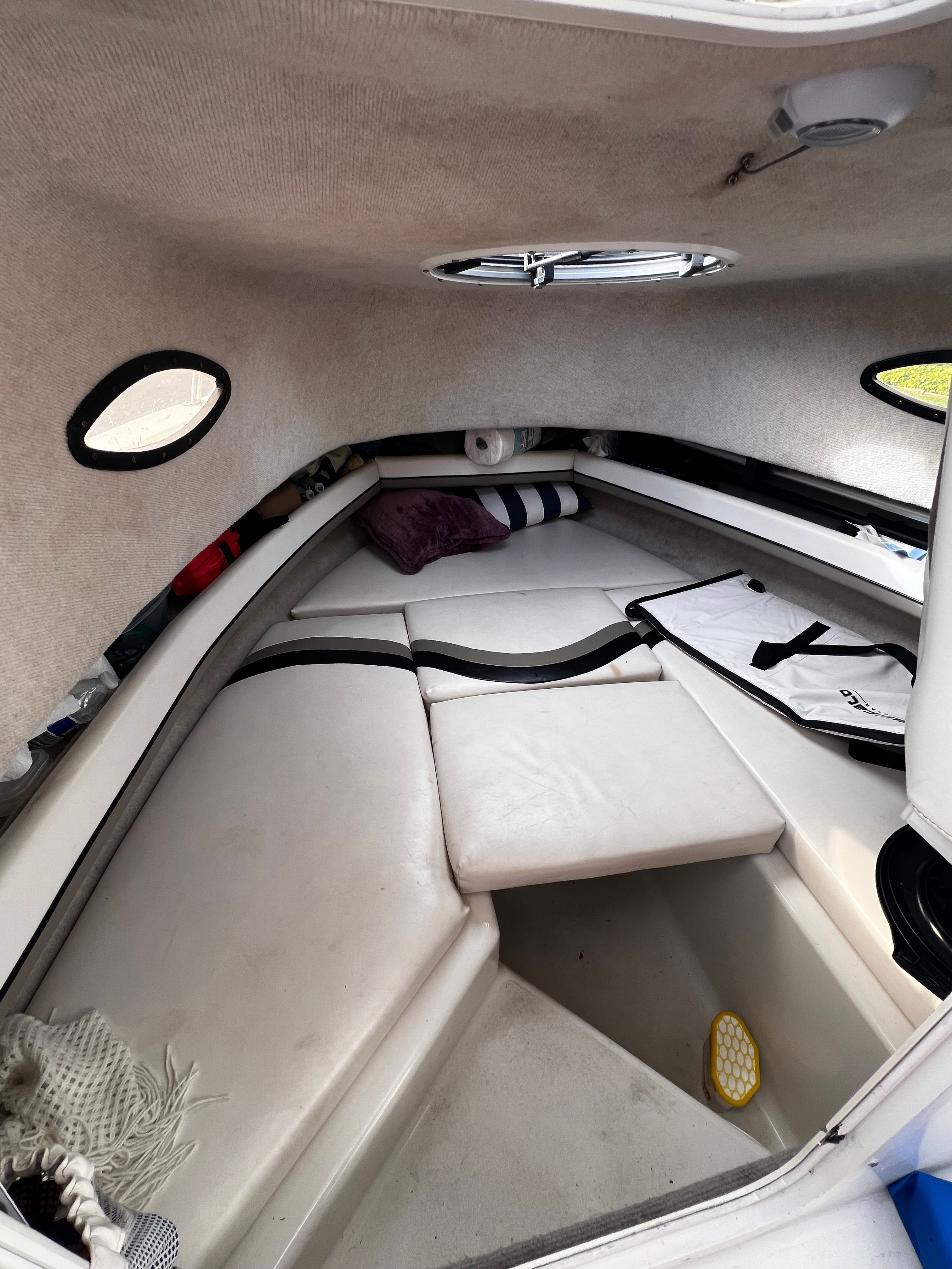 Interior of a 2001 Seaswirl Striper 1851 WA with cushioned seating and portholes.