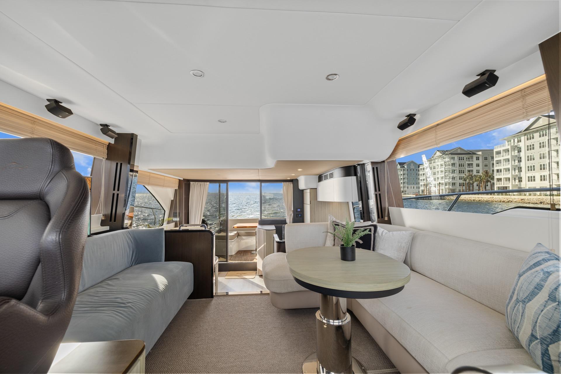 Luxurious interior of 2019 Azimut 55 yacht with modern seating and panoramic windows.