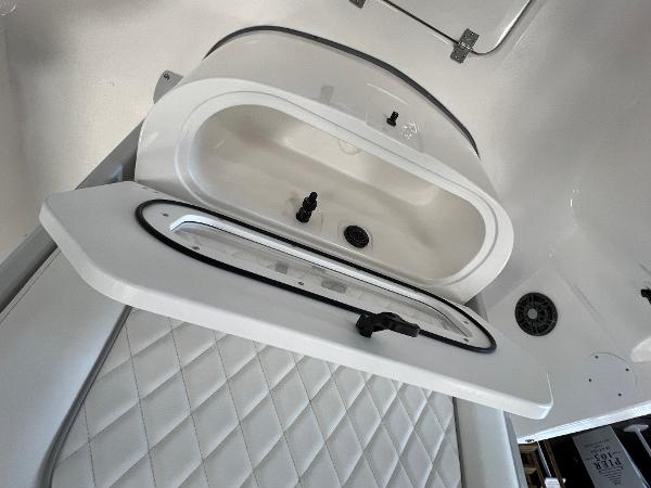 2024 Sea Fox 231 Bay boat interior storage compartment with white quilted upholstery.