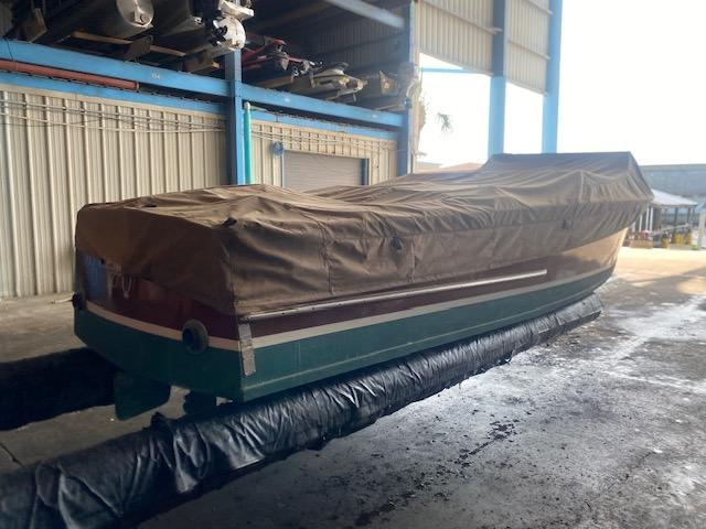 Covered 2000 Grand Craft Classic Runabout boat in storage facility.