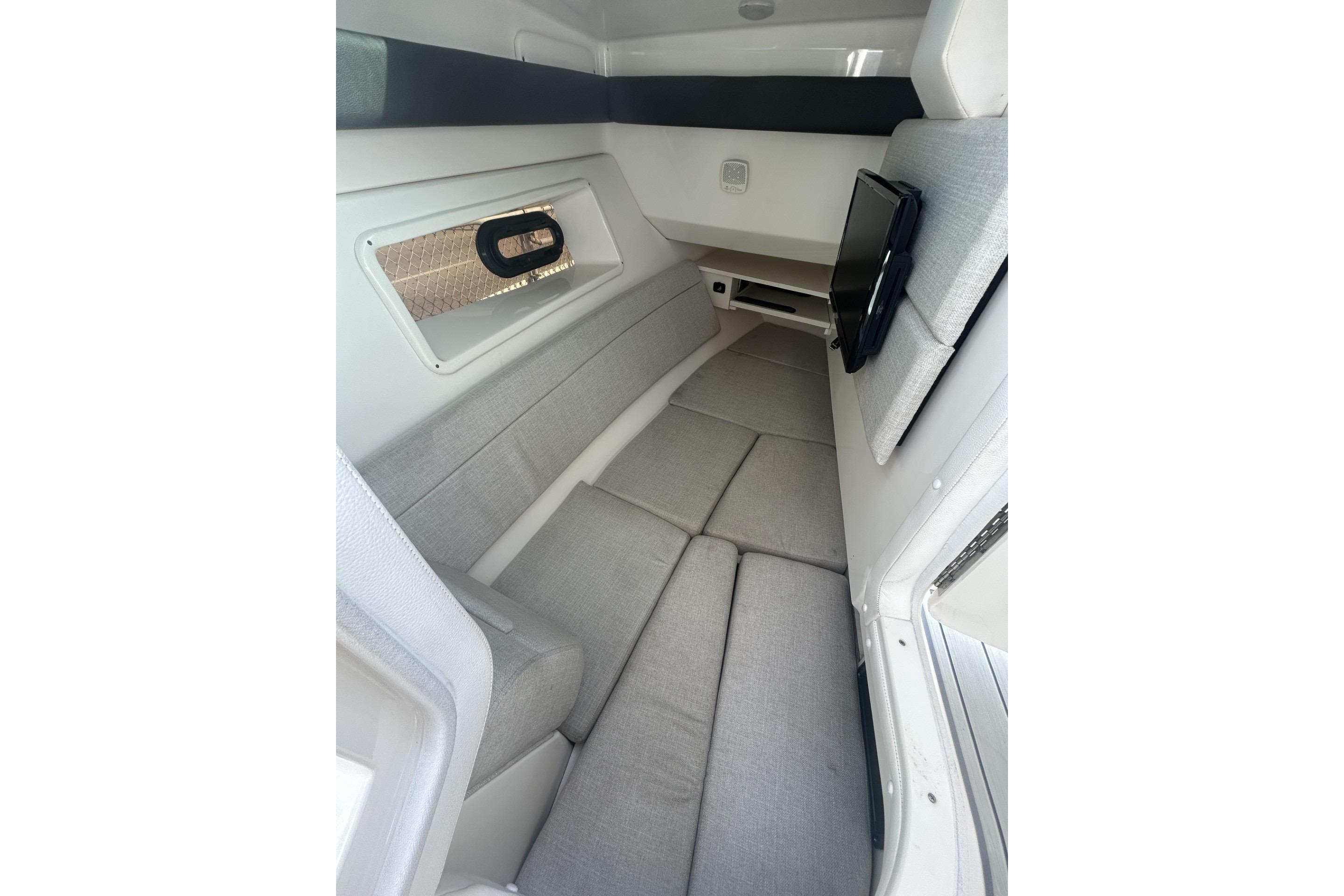 2019 Sea Ray SLX 350 Outboard cabin interior with gray seating and window.