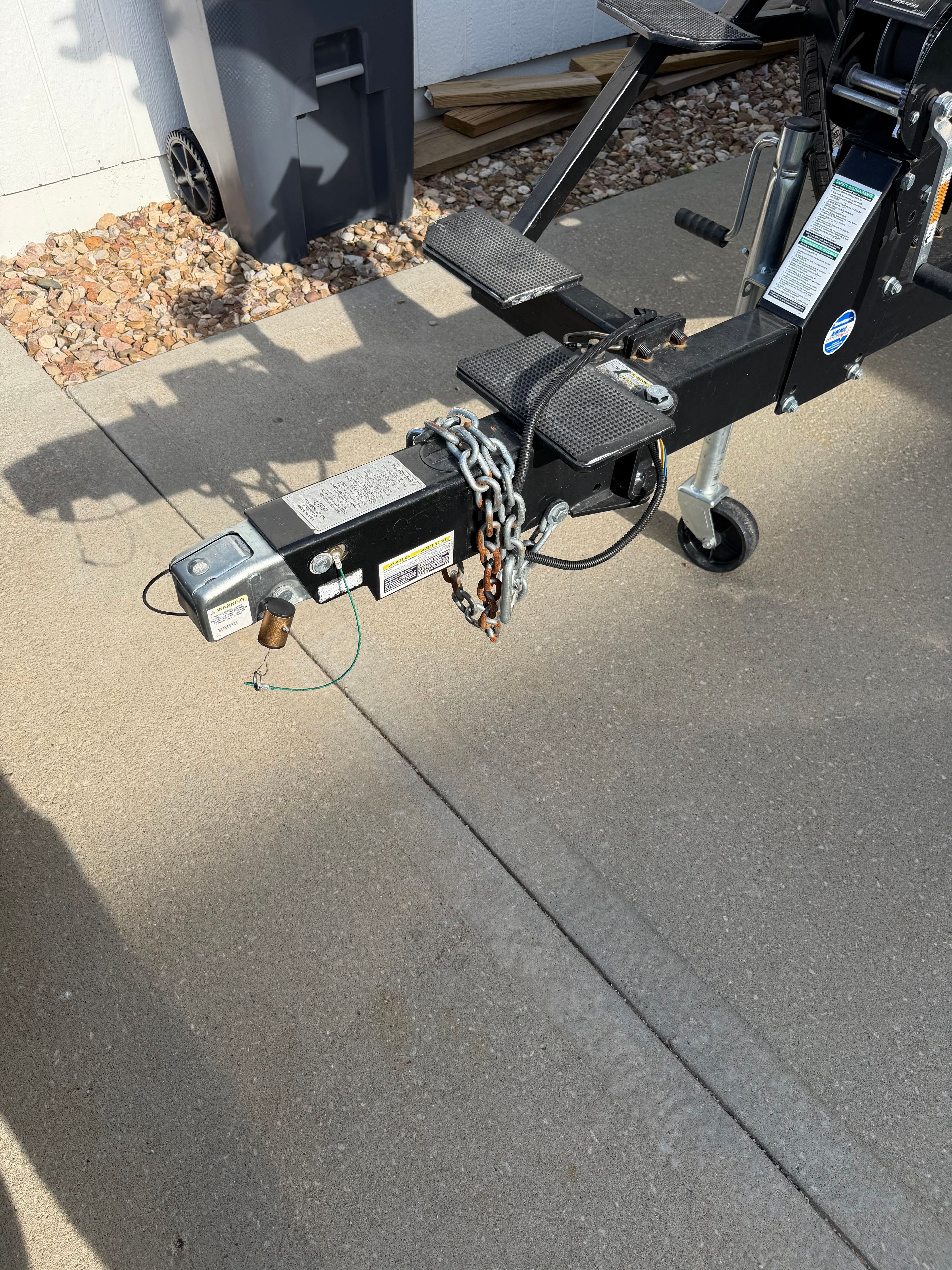 Trailer hitch of a 2017 Lund Pro v 1975 boat on concrete surface.