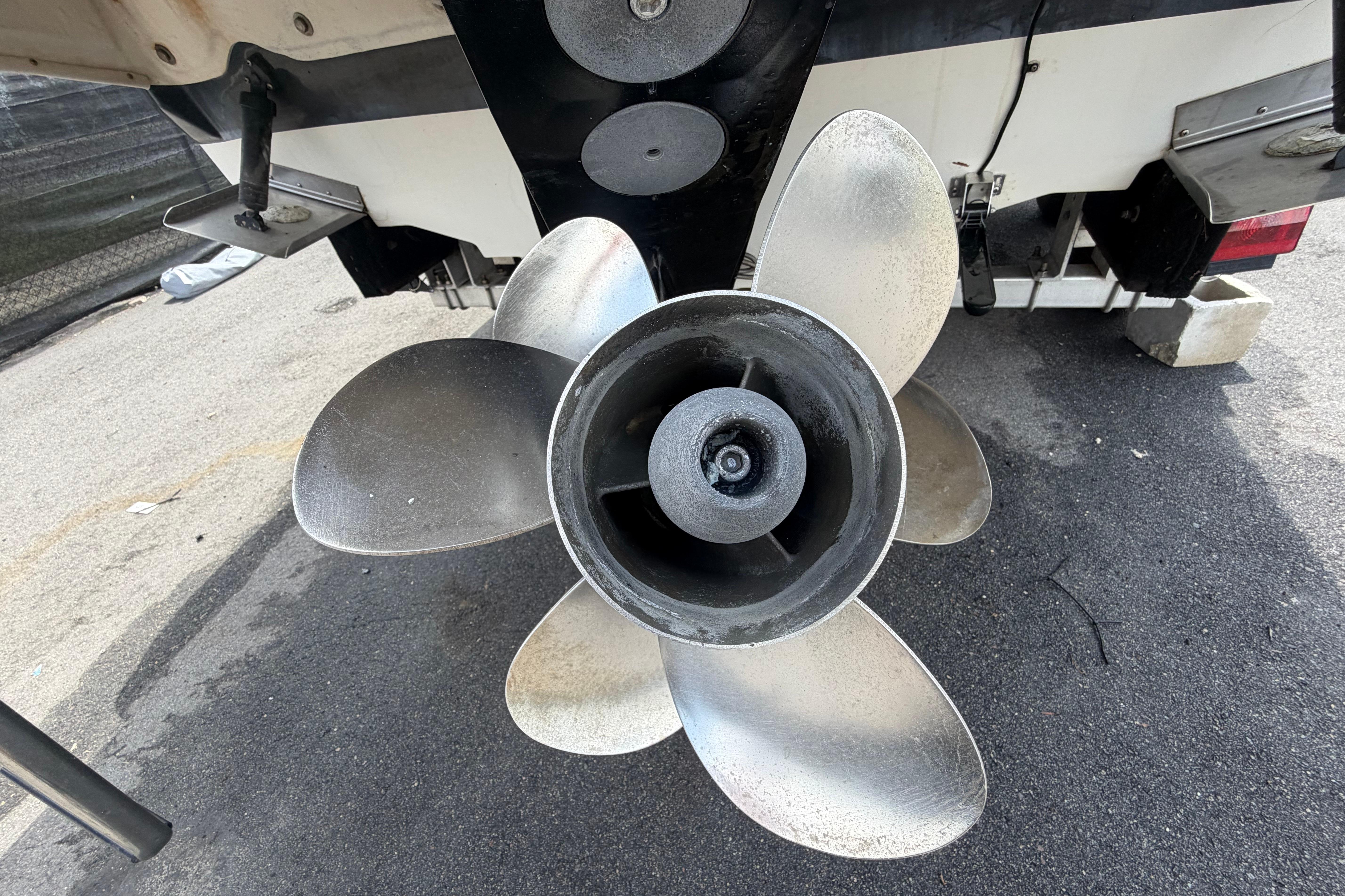 Close-up of a 2006 Sea Ray 250 Amberjack boat propeller on asphalt surface.