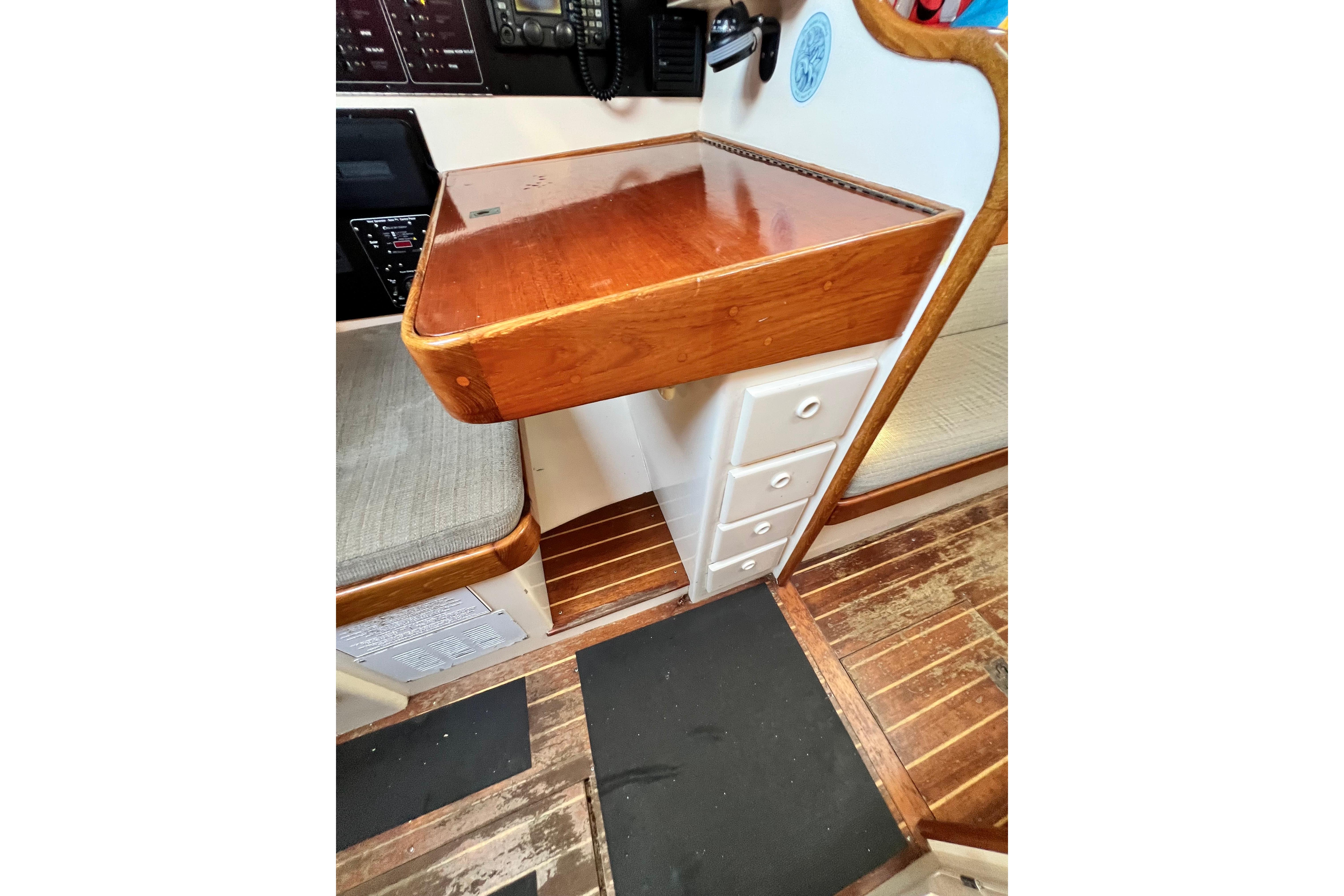 Interior of 1975 Cape George 36 sailboat with wooden desk and drawers.