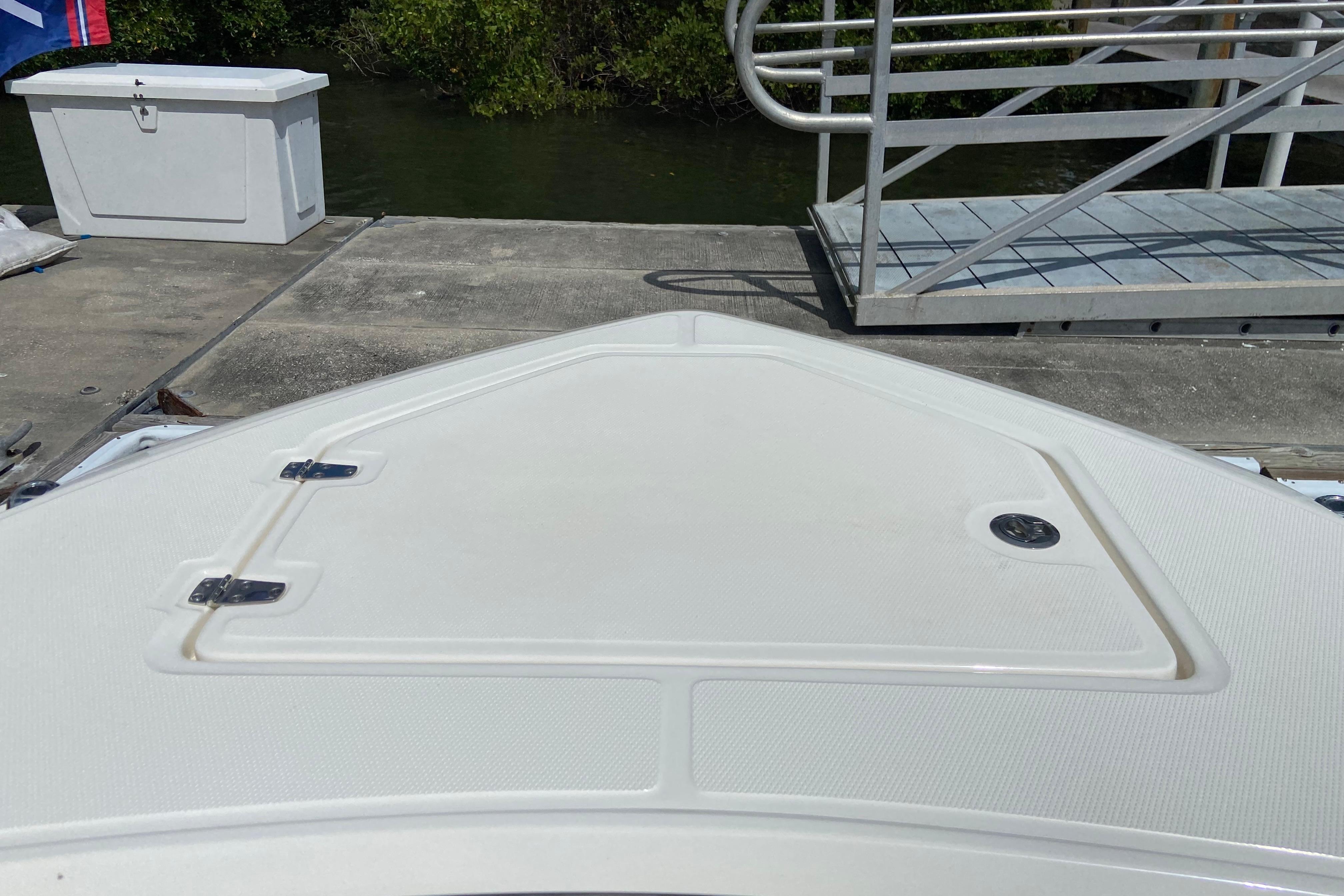 Bow of 2025 Boston Whaler 280 Outrage docked, featuring storage hatch and sleek design.