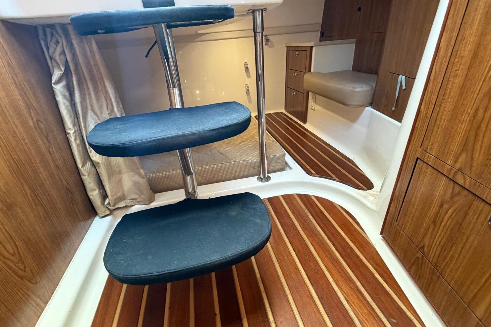 Interior of 2010 Pursuit OS 345 Offshore boat with wooden flooring and compact seating.