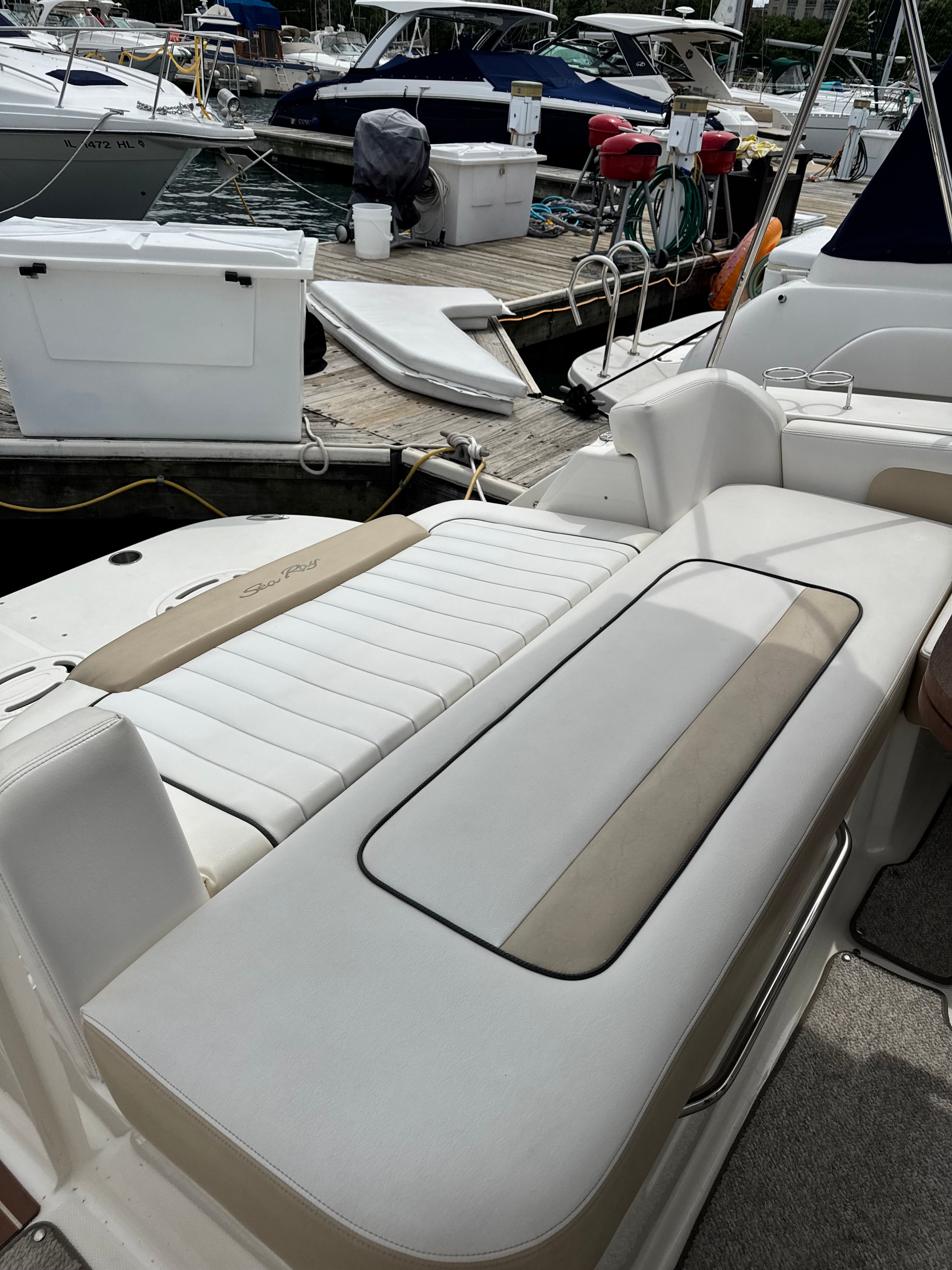 The image shows the cockpit of a Sea Ray Sundancer 310 with comfortable seating and a lounging area.
