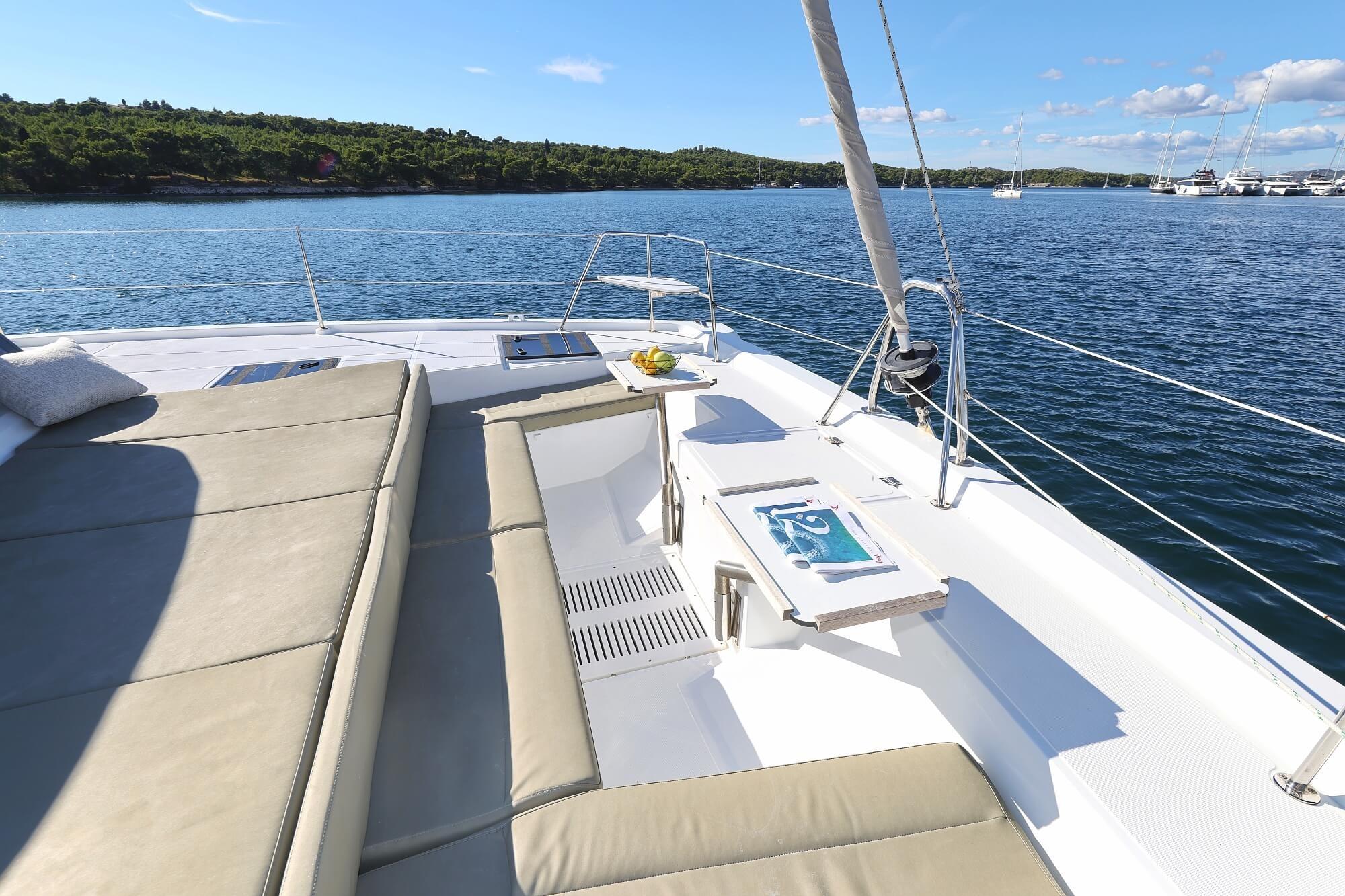 Luxurious 2025 Bali CATSPACE catamaran deck with sun loungers, sailing on serene waters.
