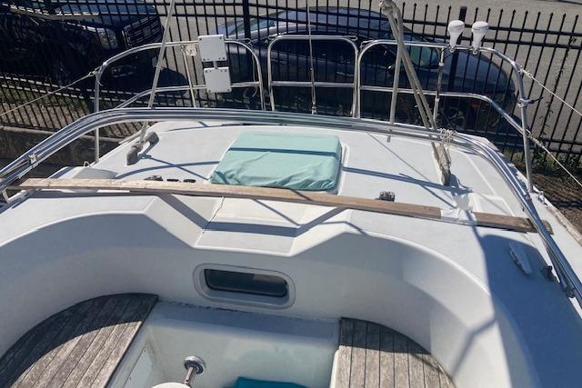 1988 Westerly Corsair 36 sailboat deck with seating and railing, parked near a fence.