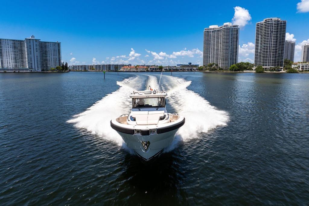 Bluegame BG 42 yacht cruising in a city waterway, 2021 model.