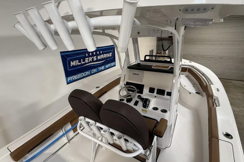 2026 Sea Pro 242 Center Console boat interior with helm and rod holders.