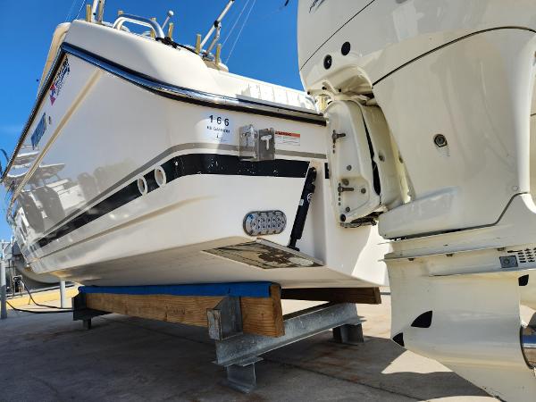 2005 Pursuit 3070 Offshore Center Console boat on a stand, rear view with outboard motor.