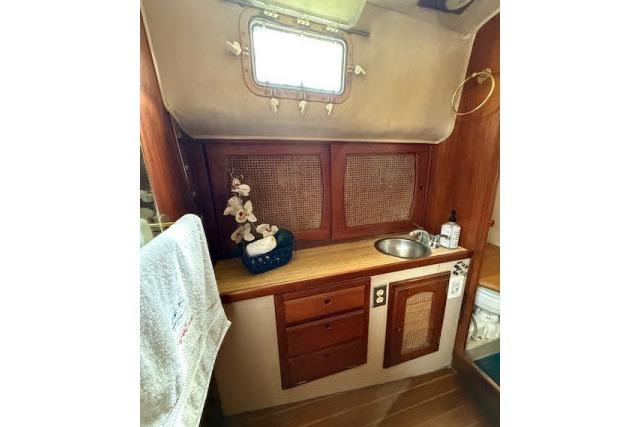 1982 Lancer 45 Motorsailer interior with wooden cabinetry, sink, and decorative elements.