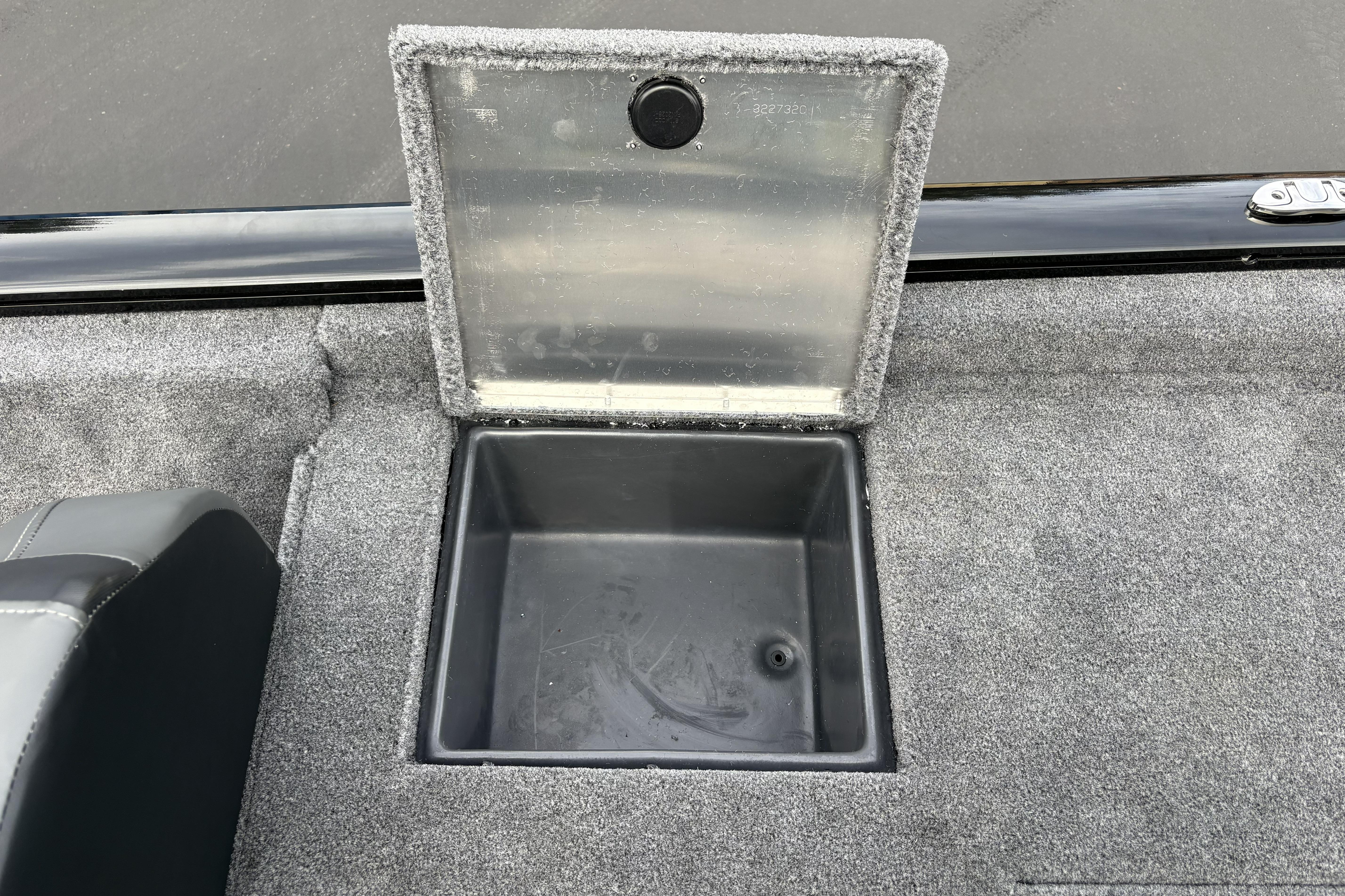 Open storage compartment on 2026 Tracker Pro Team 195 boat, featuring carpeted interior.