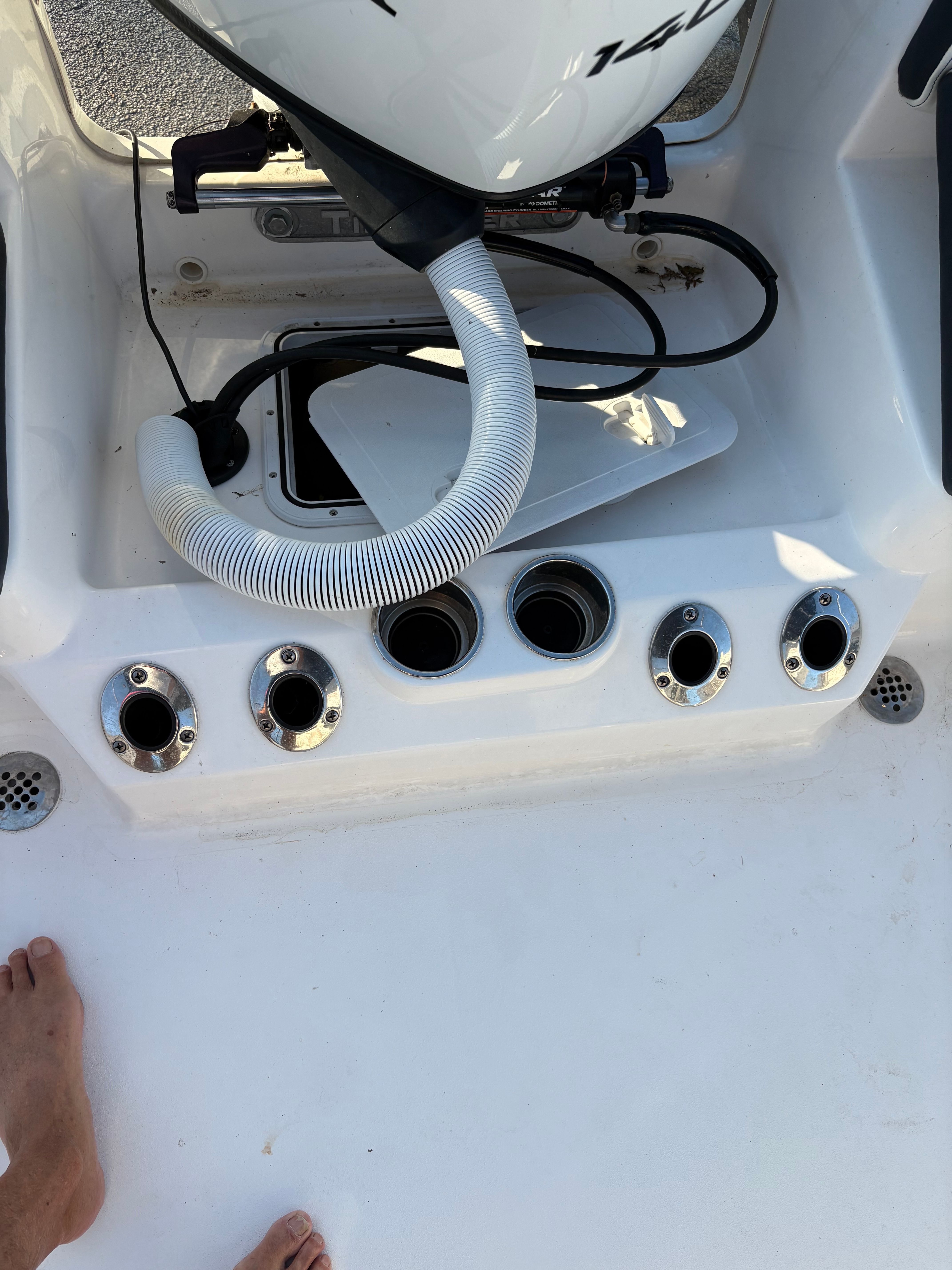 The image shows the stern of a boat with multiple fishing rod holders and an engine.