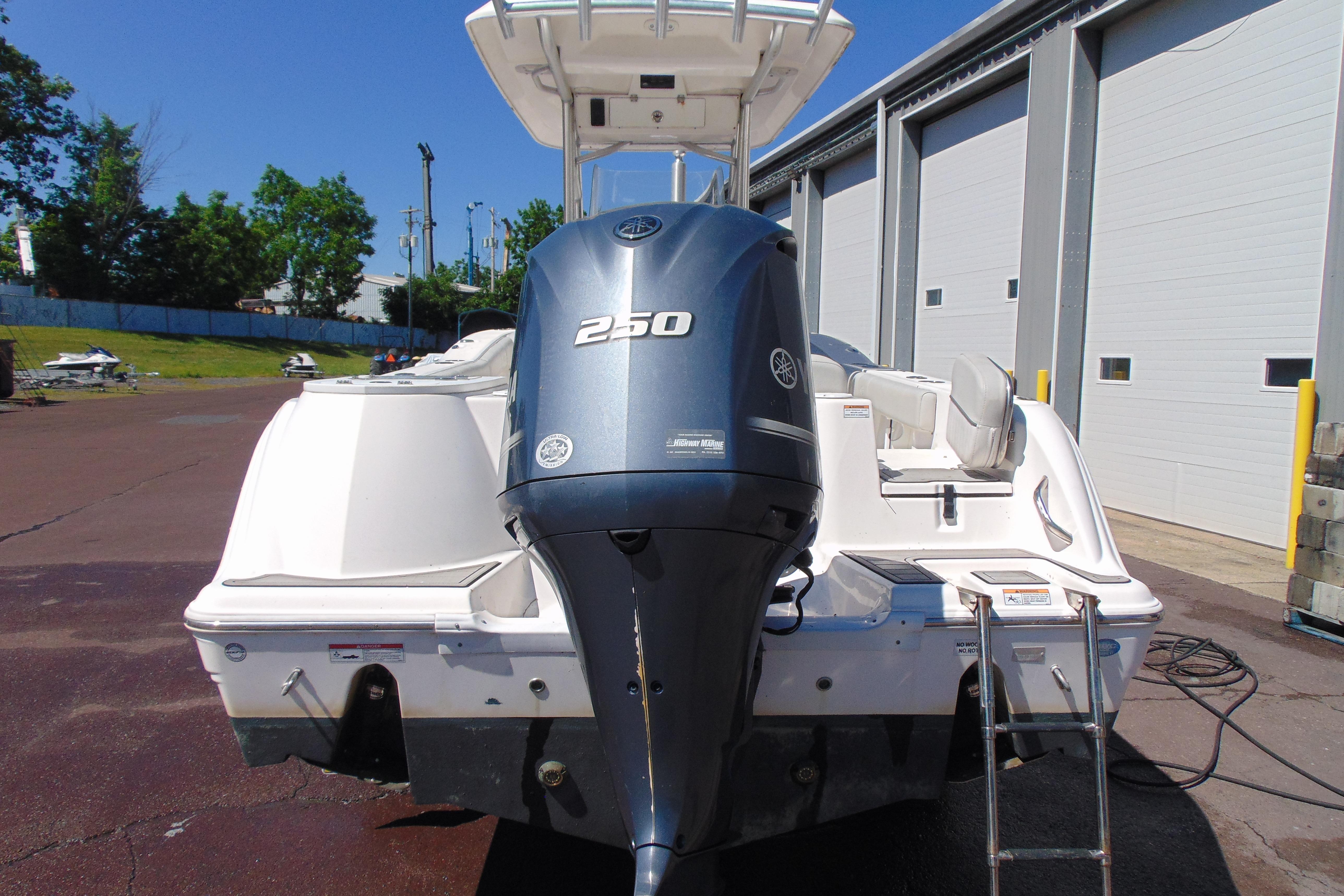 2022 Sea Fox 248 Commander boat with Yamaha 250 engine, parked near a warehouse.