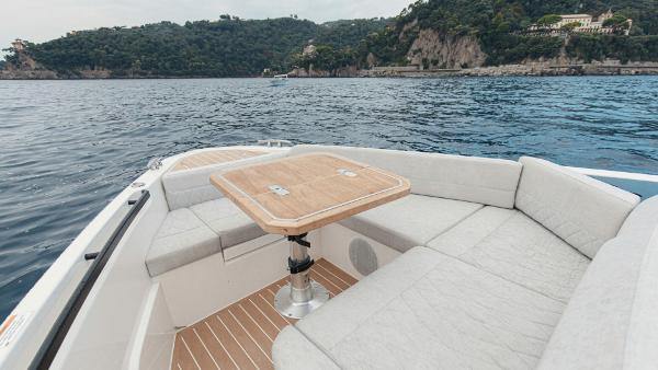 Luxurious seating area on the 2025 Saxdor 400 GTC boat with scenic coastal backdrop.