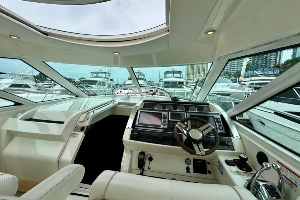Interior view of 2011 Sea Ray 450 Sundancer yacht cockpit with marina backdrop.