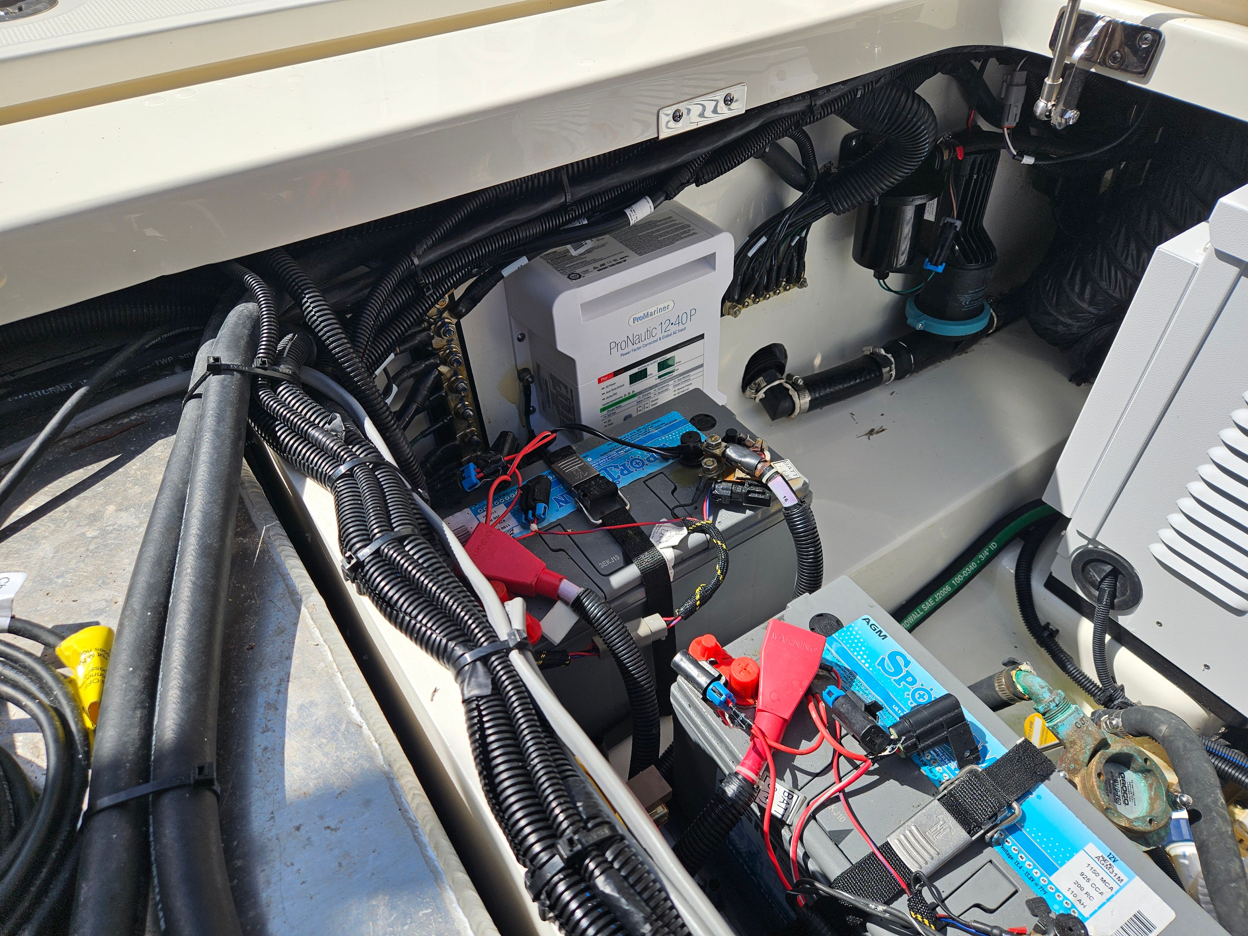 View of a Boston Whaler 325 Conquest engine compartment with batteries and wiring.