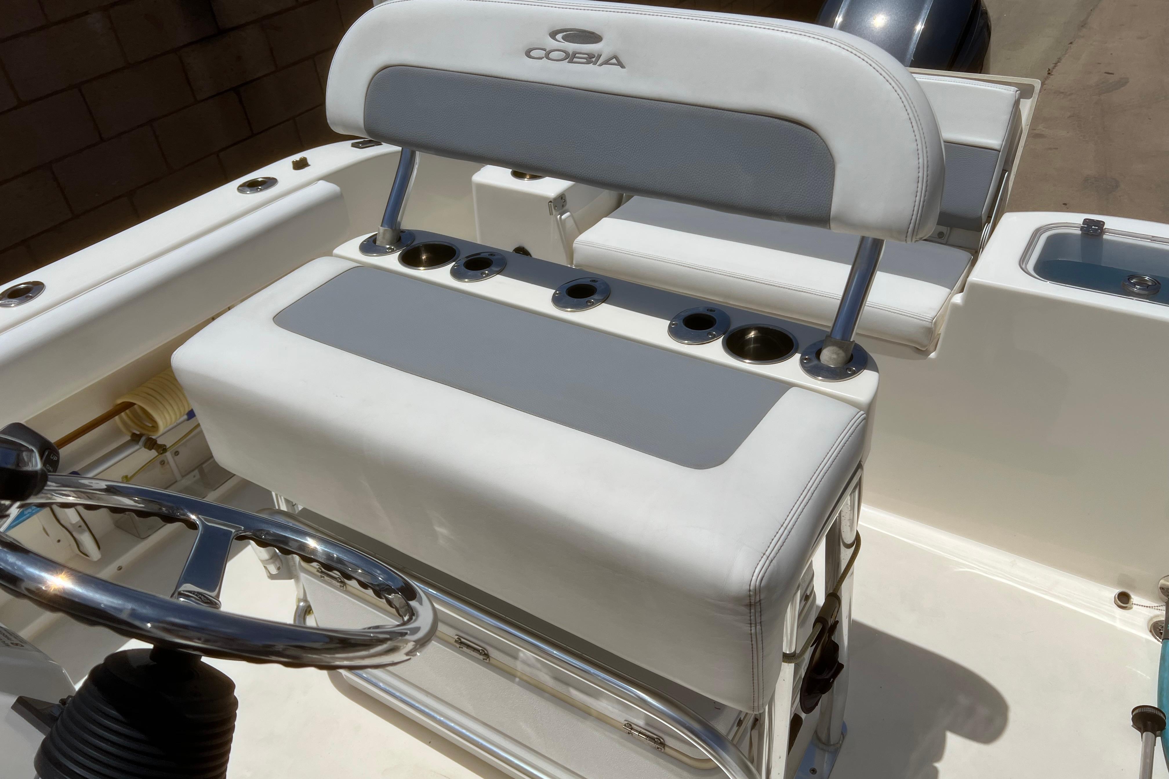 2018 Cobia 201 Center Console boat interior with steering wheel and seating area.