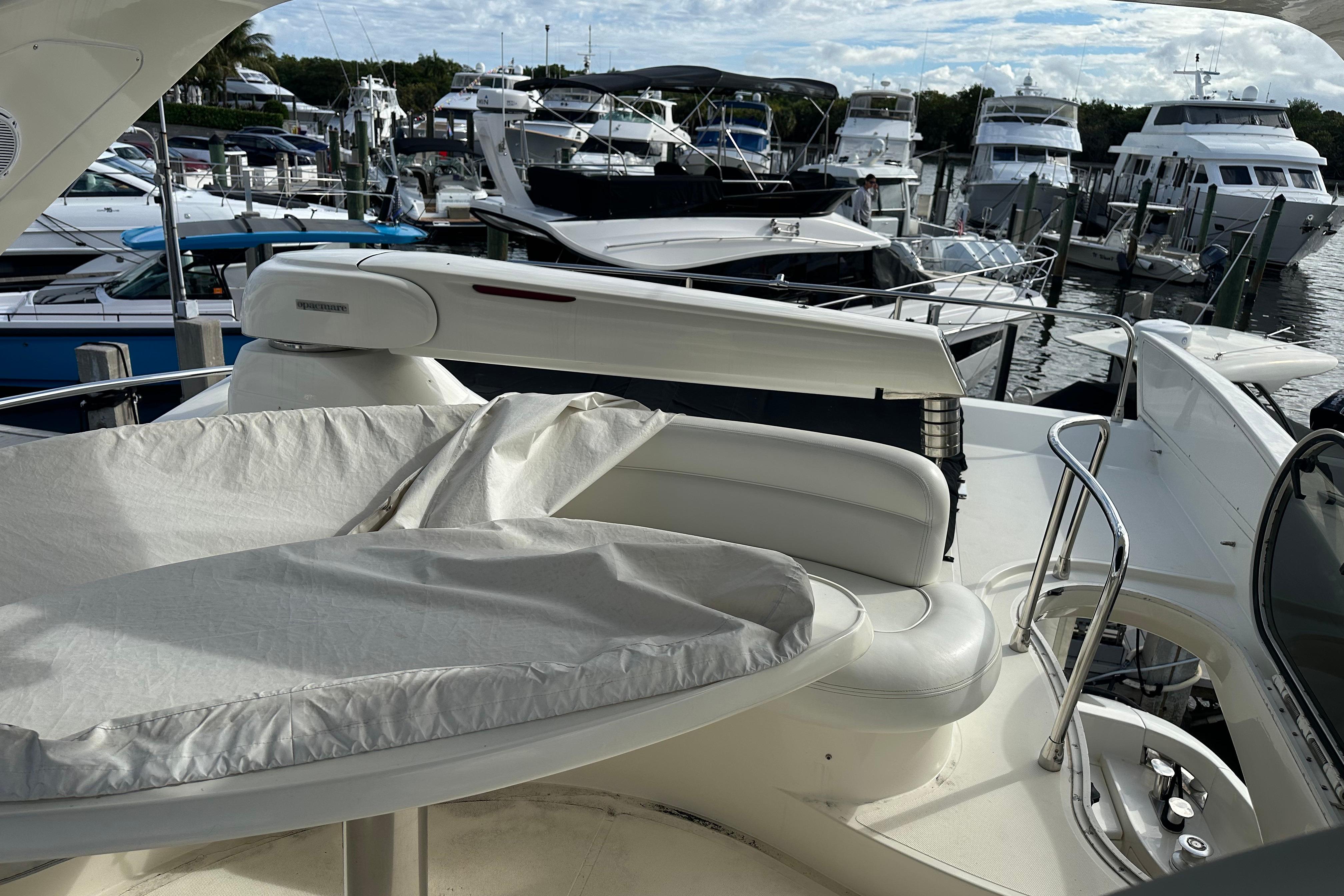 2004 Azimut 55E yacht with covered seating area, docked among other luxury boats.