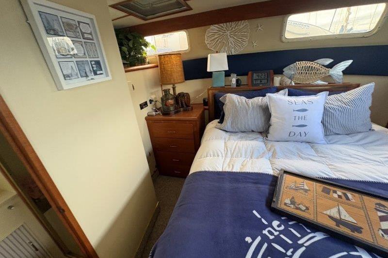 1987 Tollycraft 34 Sundeck Motor Yacht bedroom with nautical decor and cozy bedding.