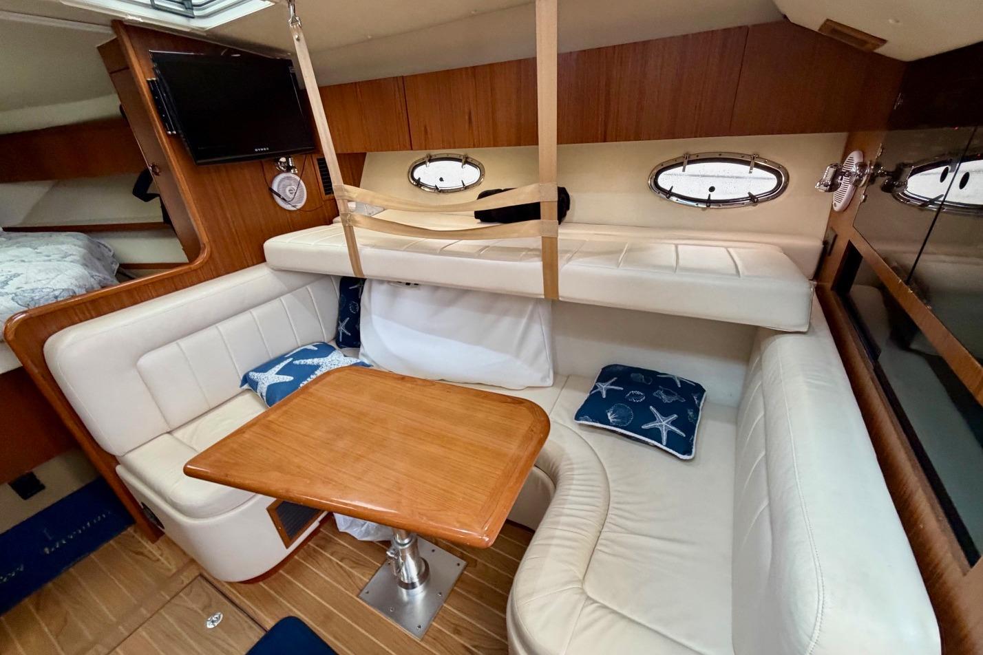 2003 Tiara Yachts 3500 Open cabin interior with cozy seating and wooden table.