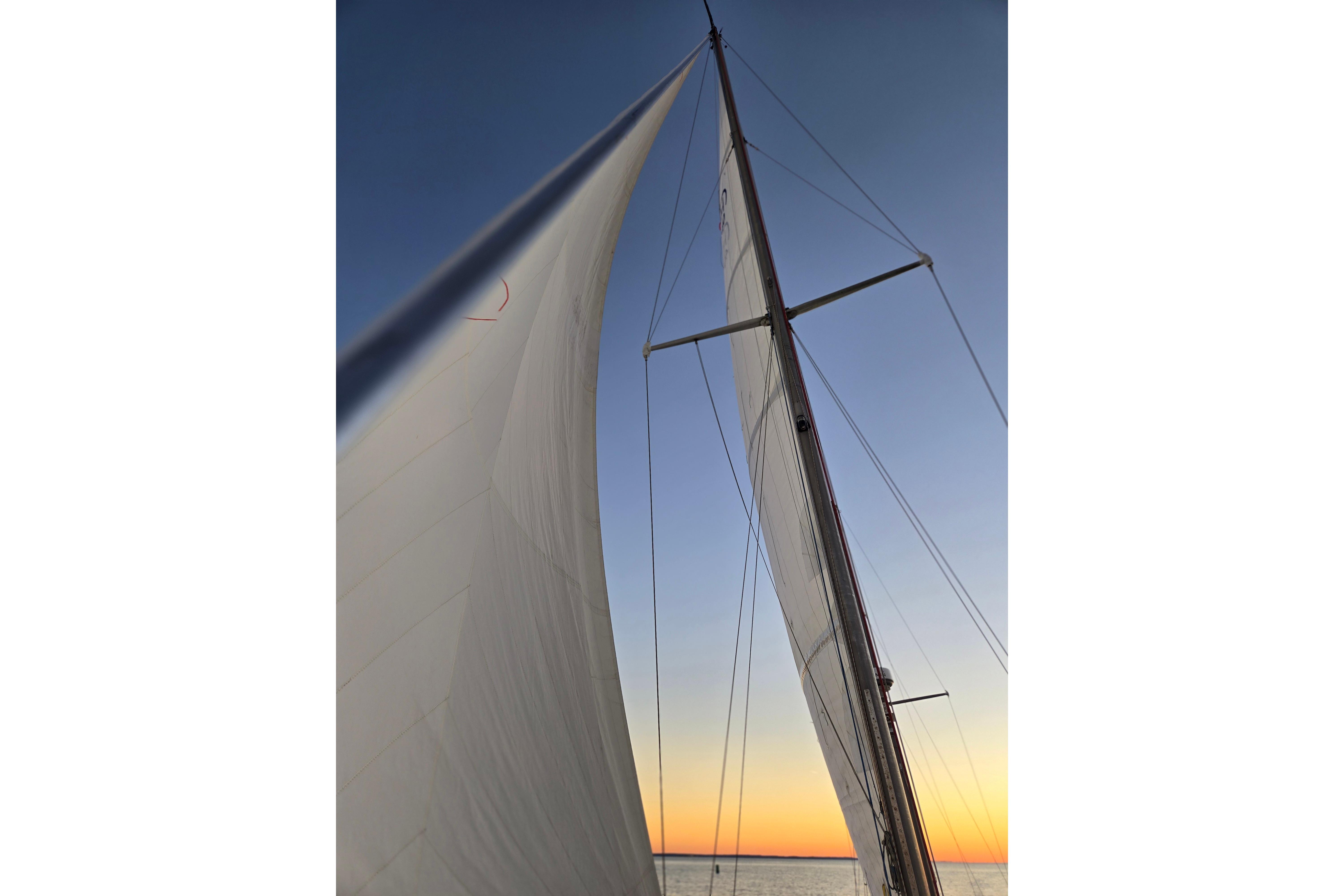 Sailing yacht Hinckley Bermuda 40 mast and sails at sunset, 1970 model.