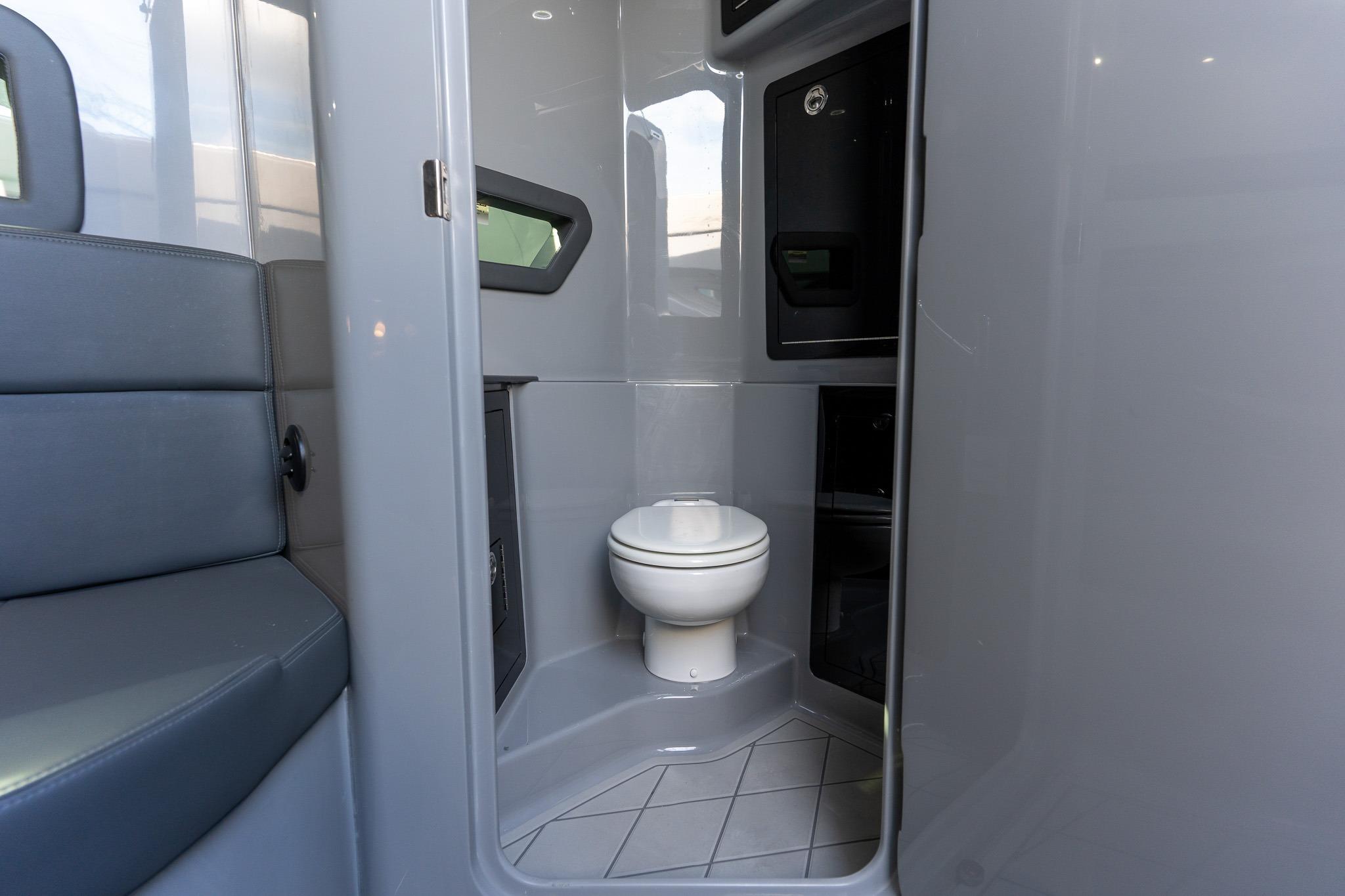 Interior of 2026 Deep Impact 499 Sport boat featuring a compact bathroom.