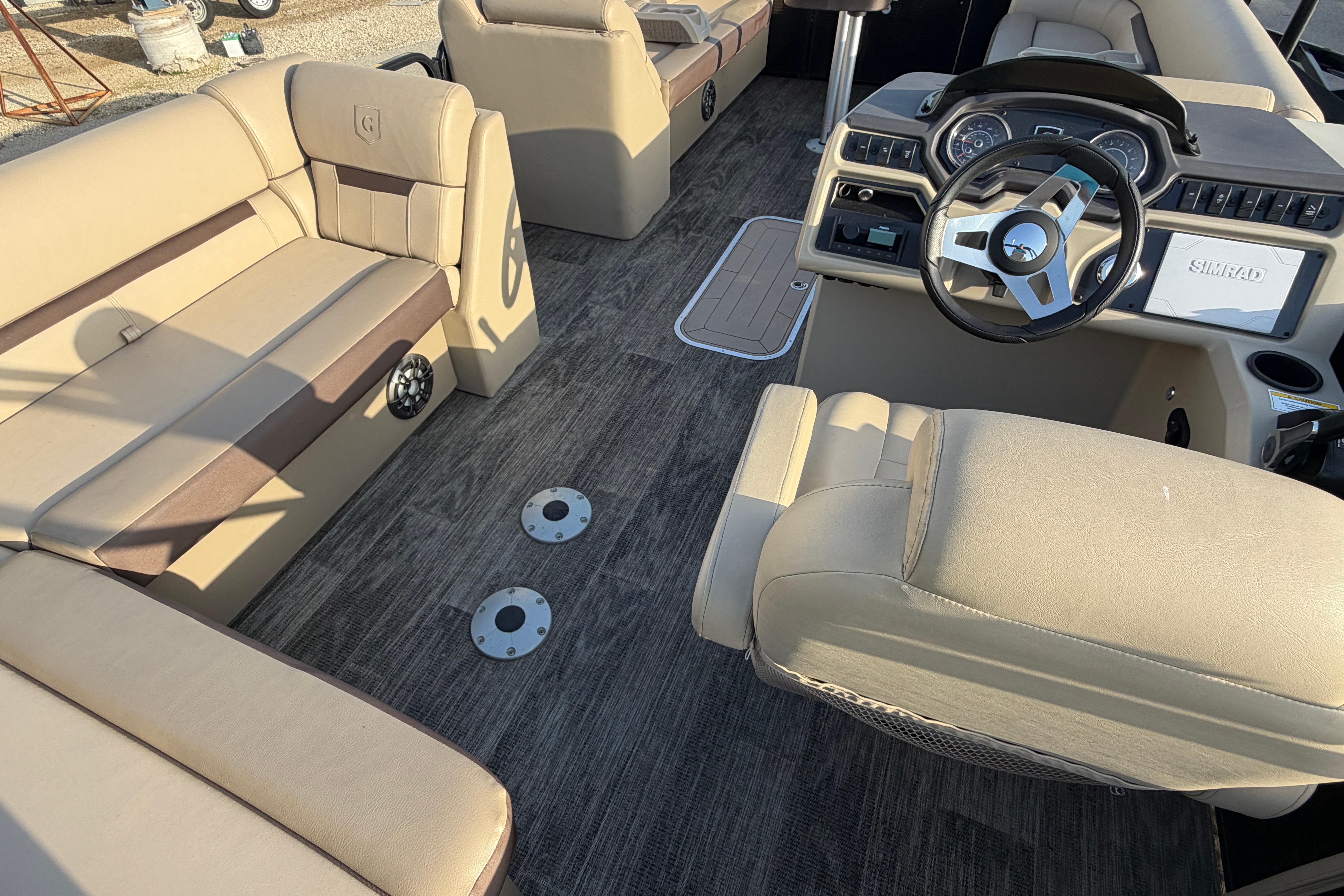 2023 Godfrey Sweetwater 2286 C pontoon boat interior with beige seating and modern dashboard.