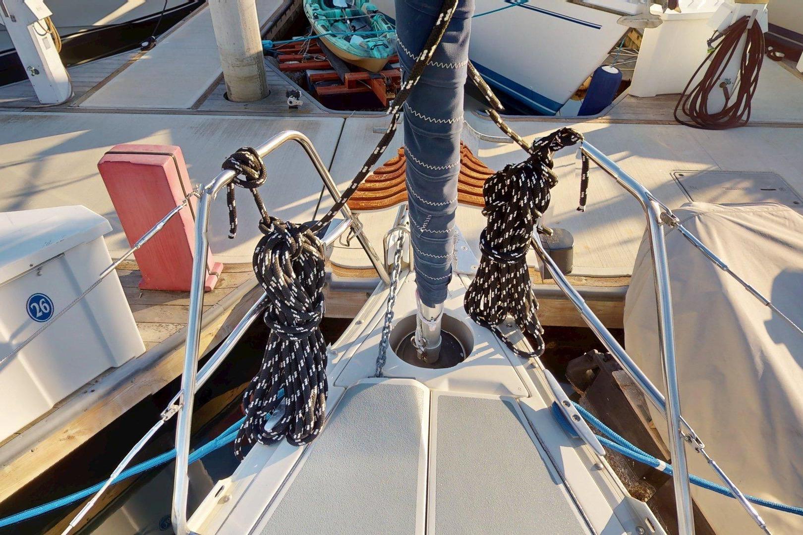 Bow of 1997 Hunter Legend 40.5 sailboat docked, featuring ropes and deck details.