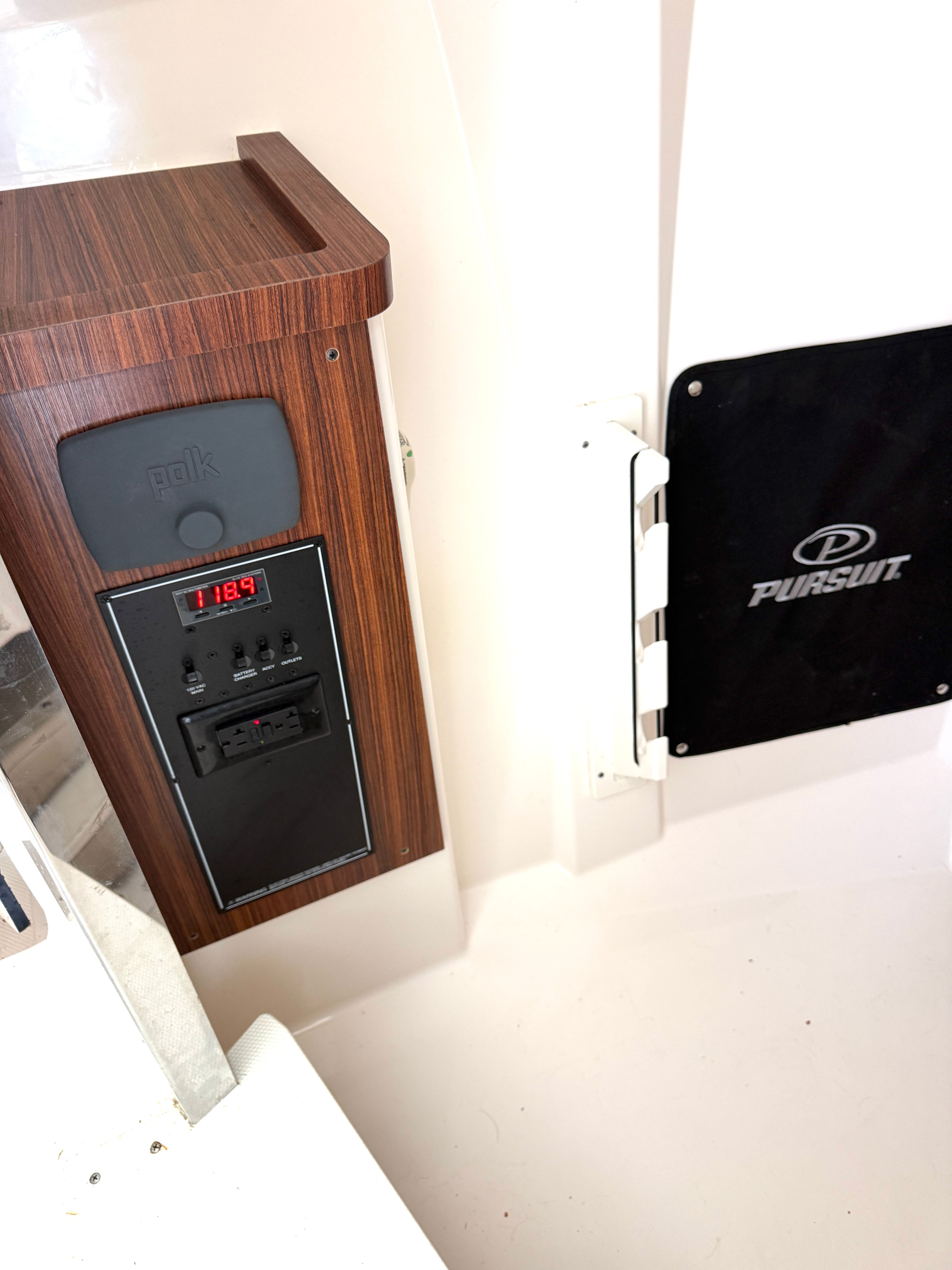 Interior view of a 2017 Pursuit DC 295 Dual Console with a wood panel and Polk audio system.