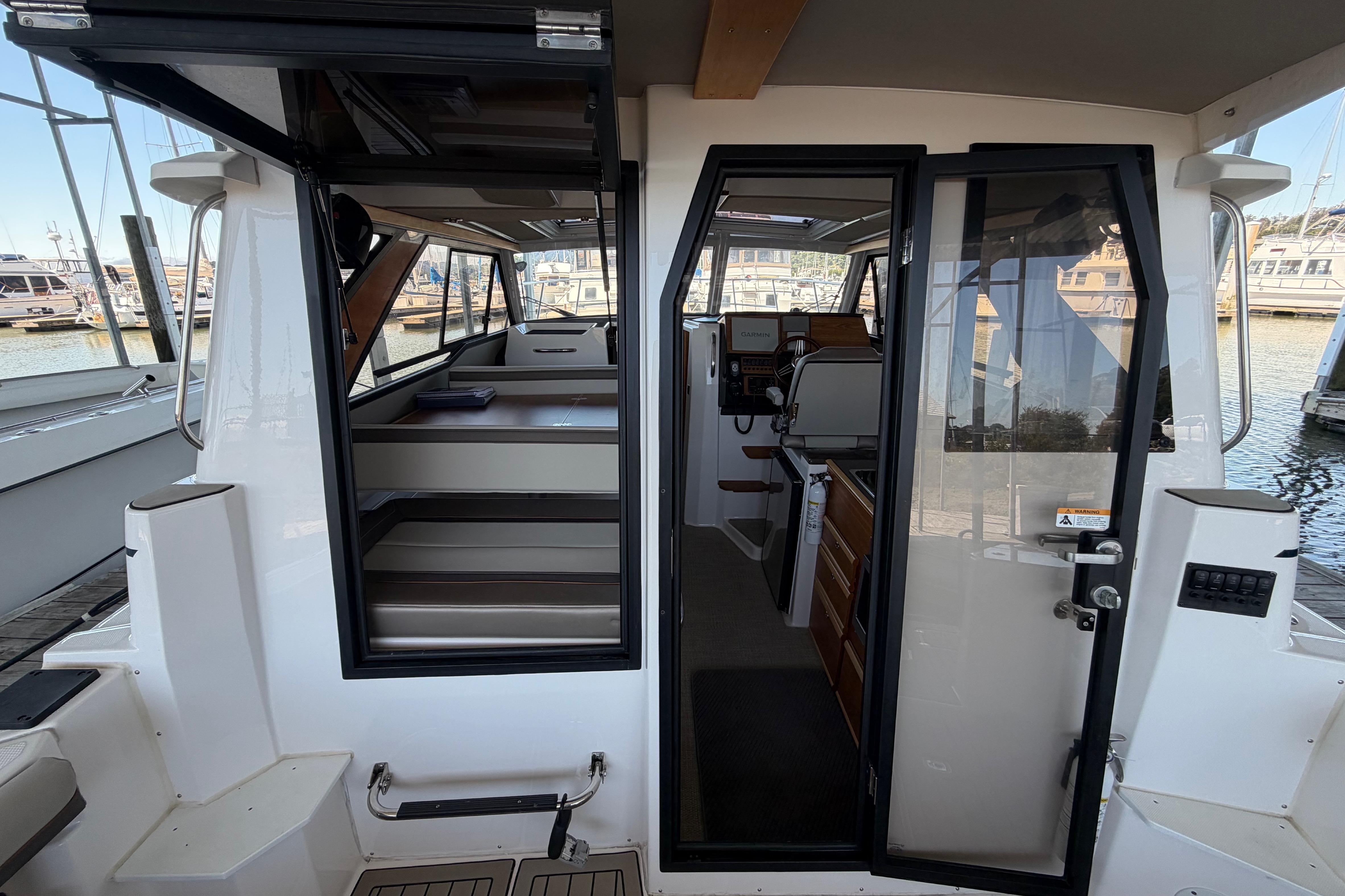 2023 Cutwater C-288 Coupe interior view, showcasing cabin and helm station at the marina.