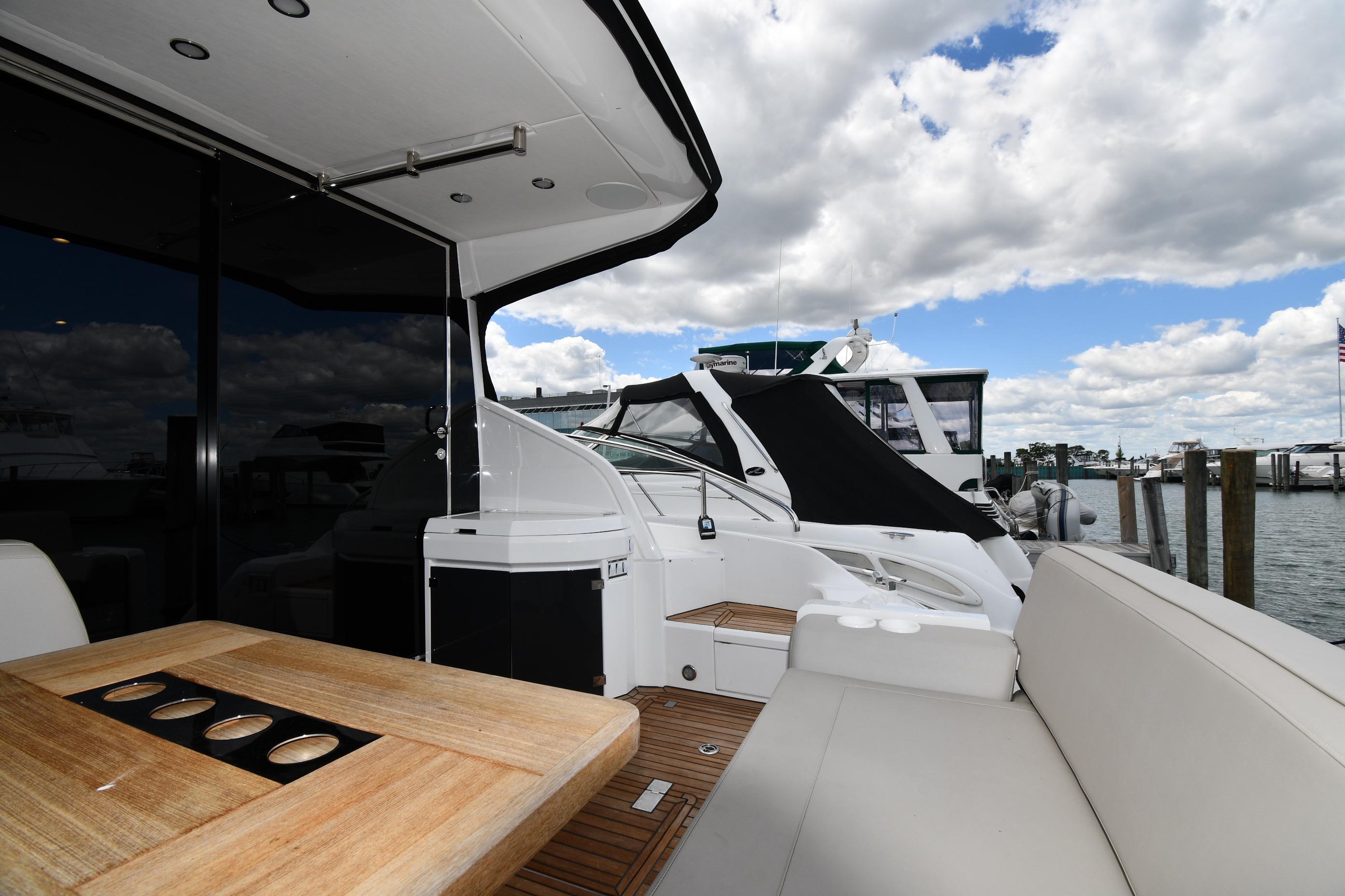 2024 Fairline G50 Targa yacht deck with seating and table, docked at marina.