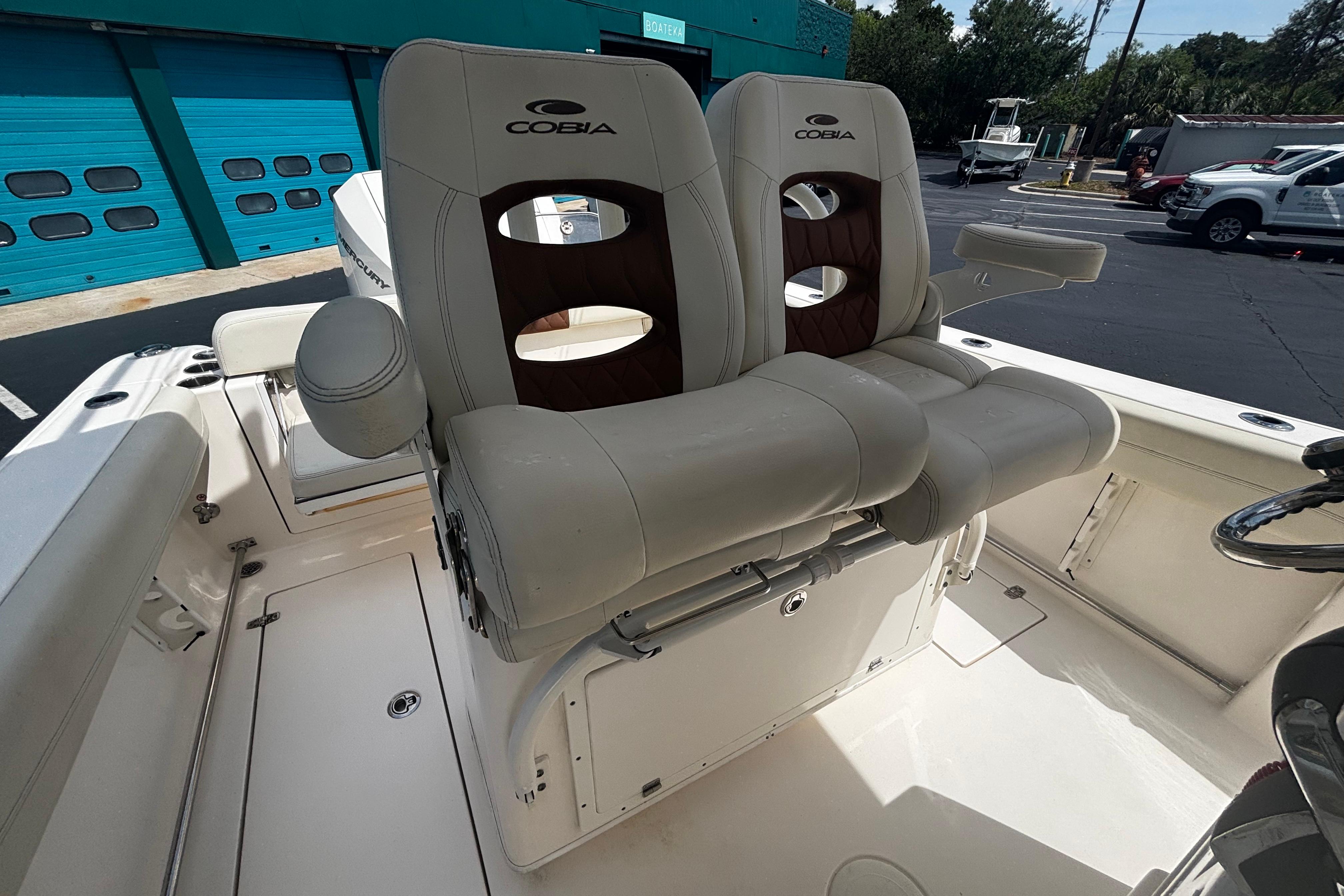 2023 Cobia 262 Center Console boat with dual cushioned seats and armrests.