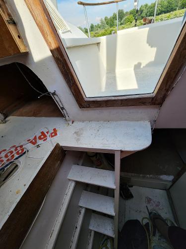 Interior view of a 1985 Crowther Buccaneer boat, featuring stairs and a window.