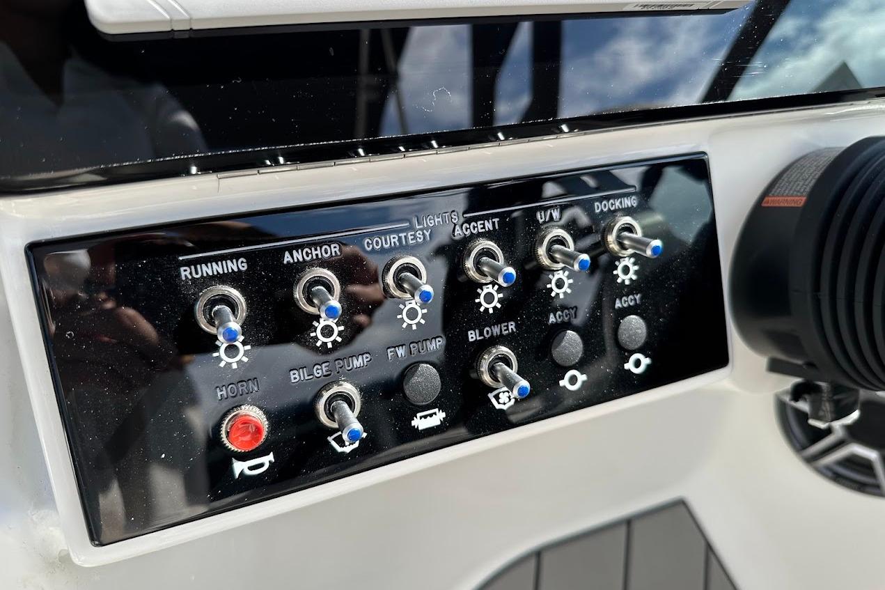 Control panel of 2026 Sea Ray SDX 230 Surf boat with various switches and buttons.