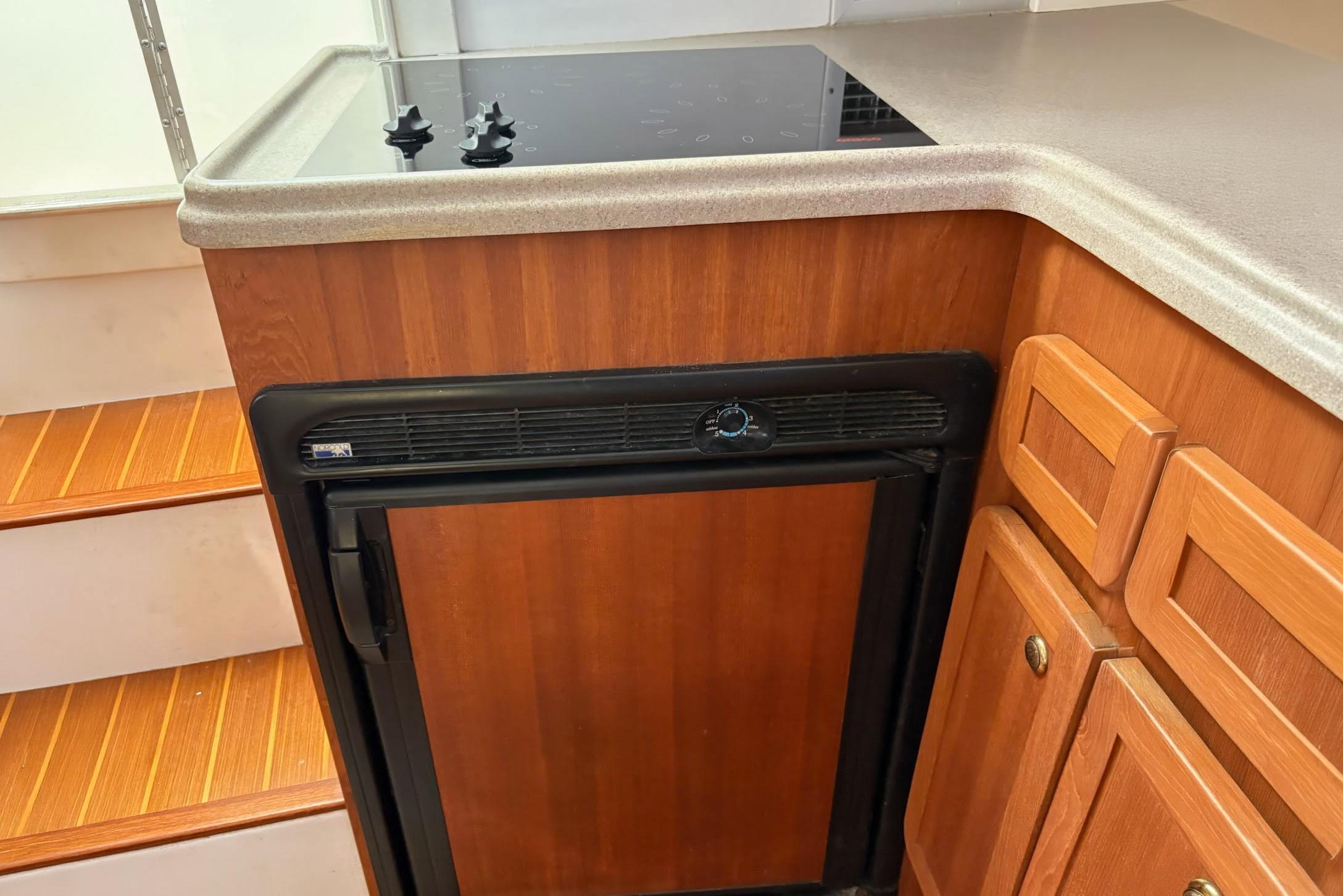 2008 Stamas 370 Express boat interior with wooden cabinetry and compact kitchen area.