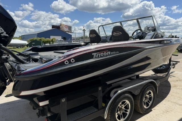 2016 Triton 216 Fishunter boat on trailer under a bright blue sky.