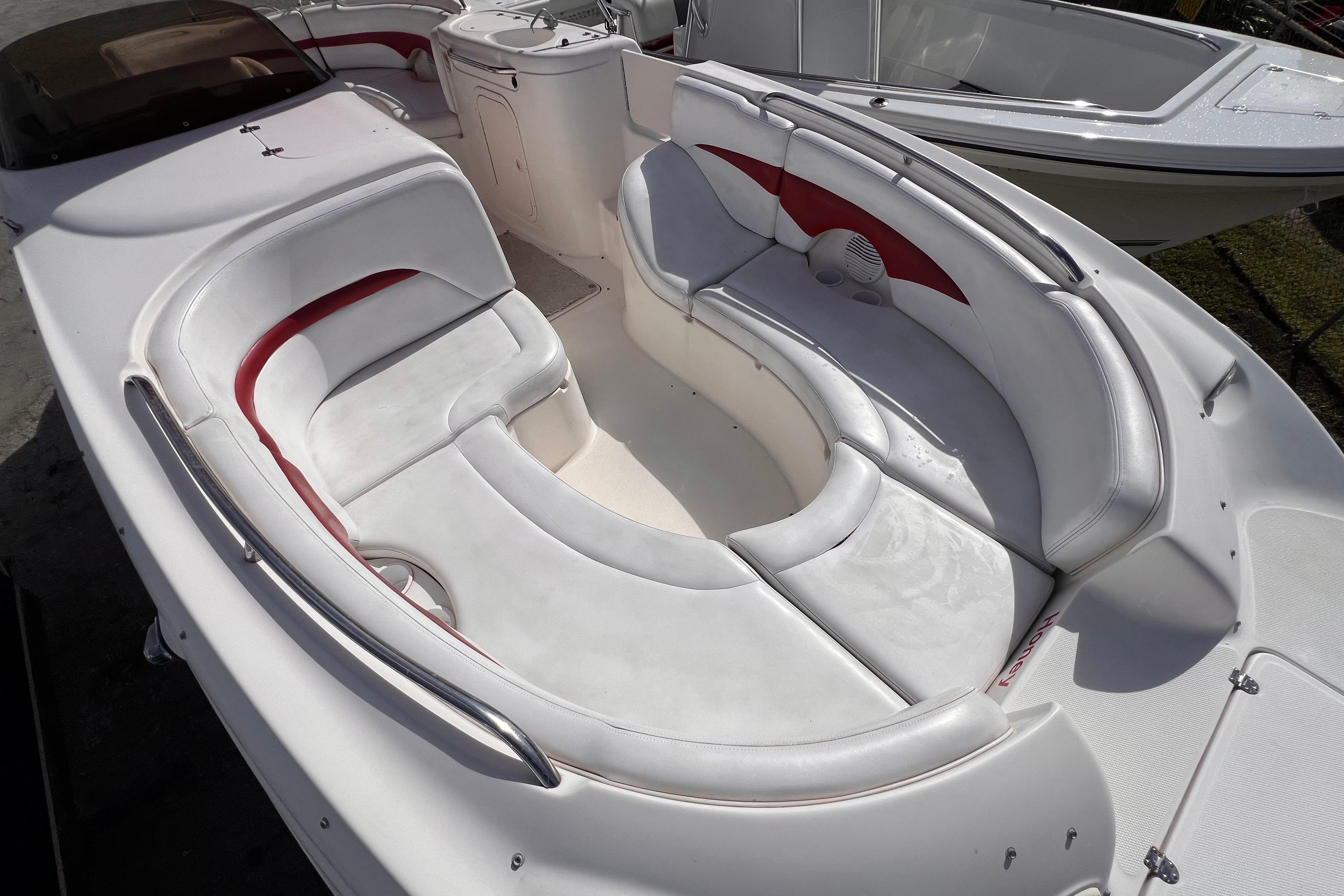 2002 Chaparral 232 Sunesta boat with spacious white and red seating area.