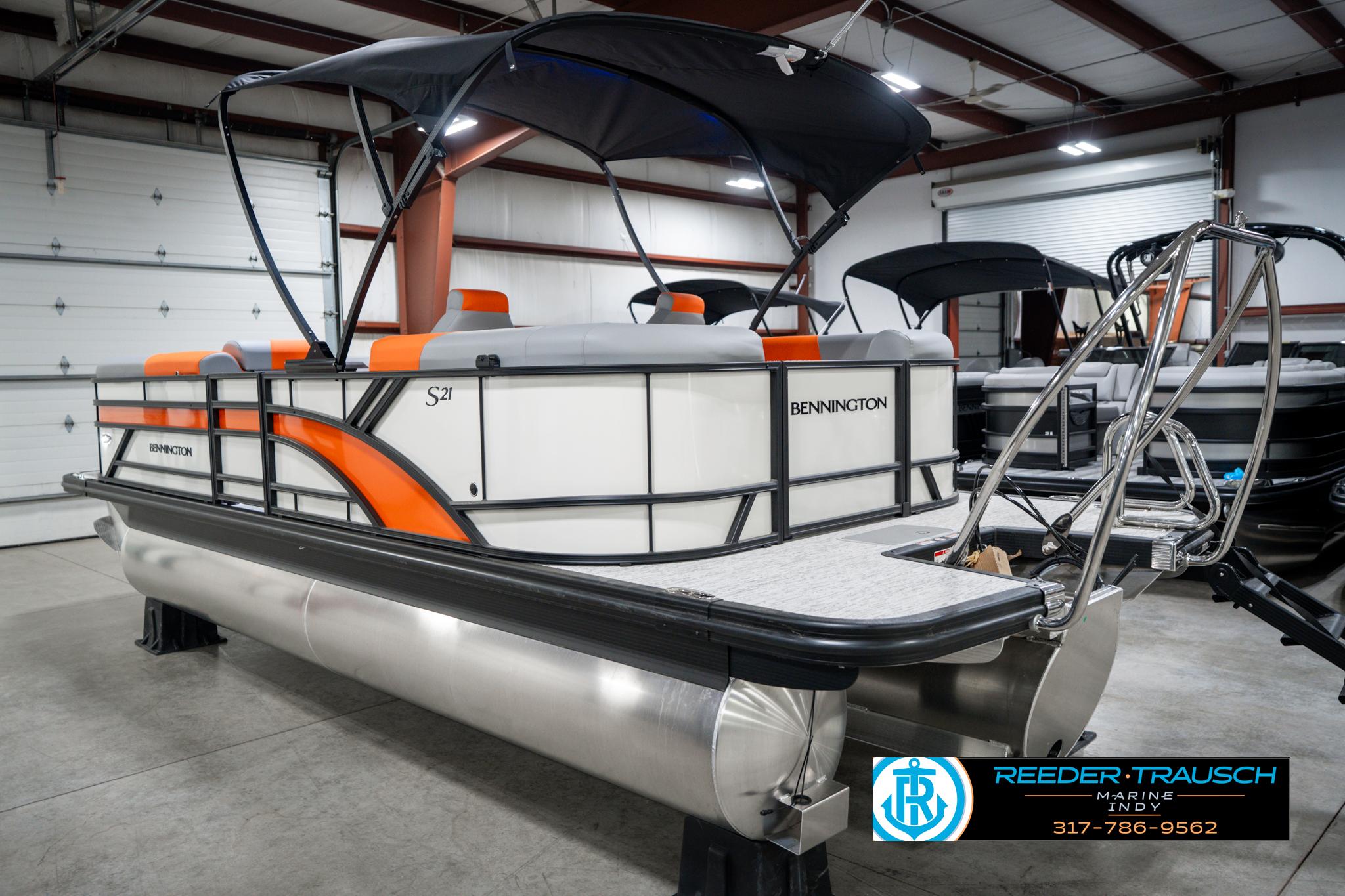 2025 Bennington 21 SSR pontoon boat with orange accents in a showroom.