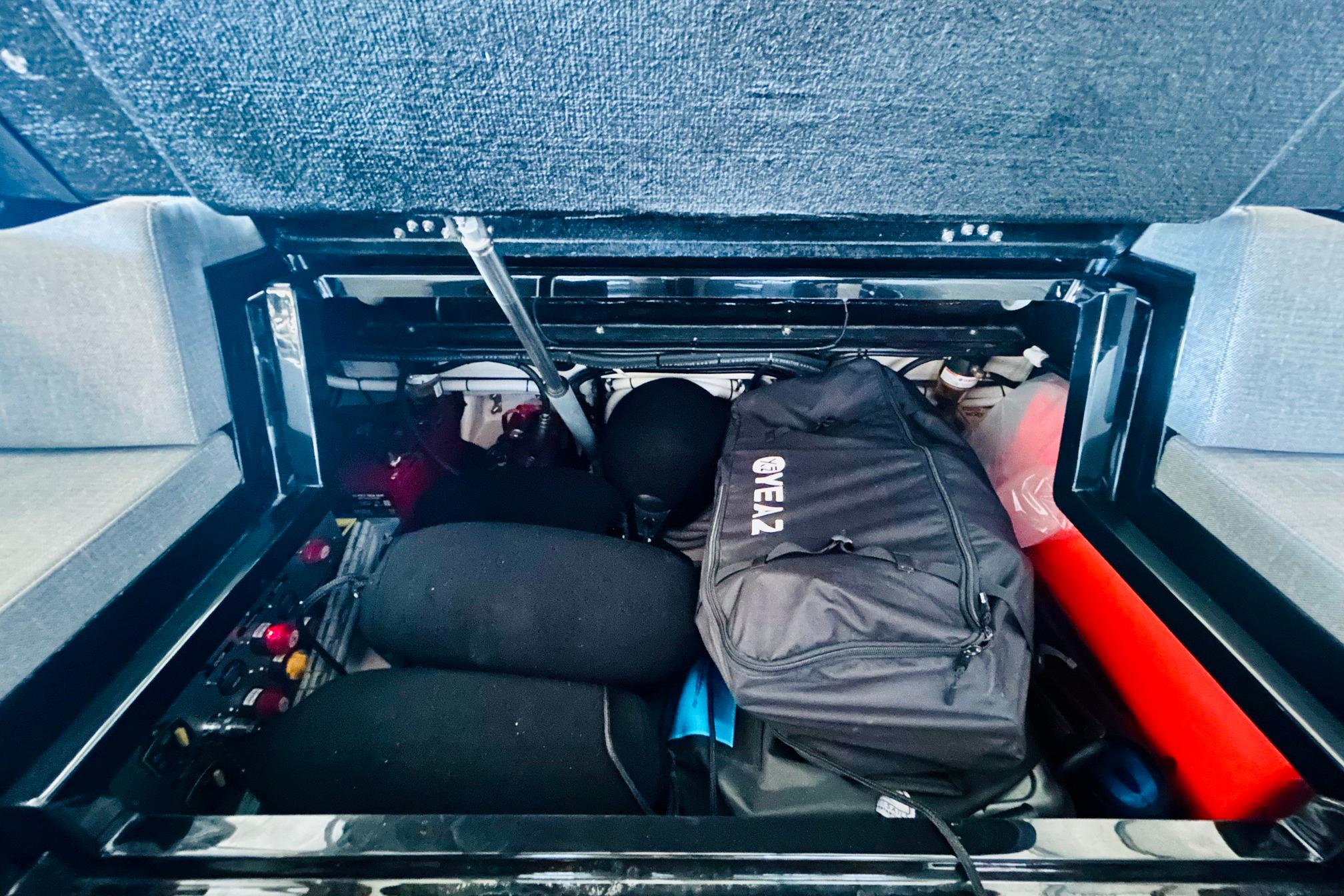 Storage compartment of 2025 Technohull Alpha 40 boat, featuring various equipment and a black bag.