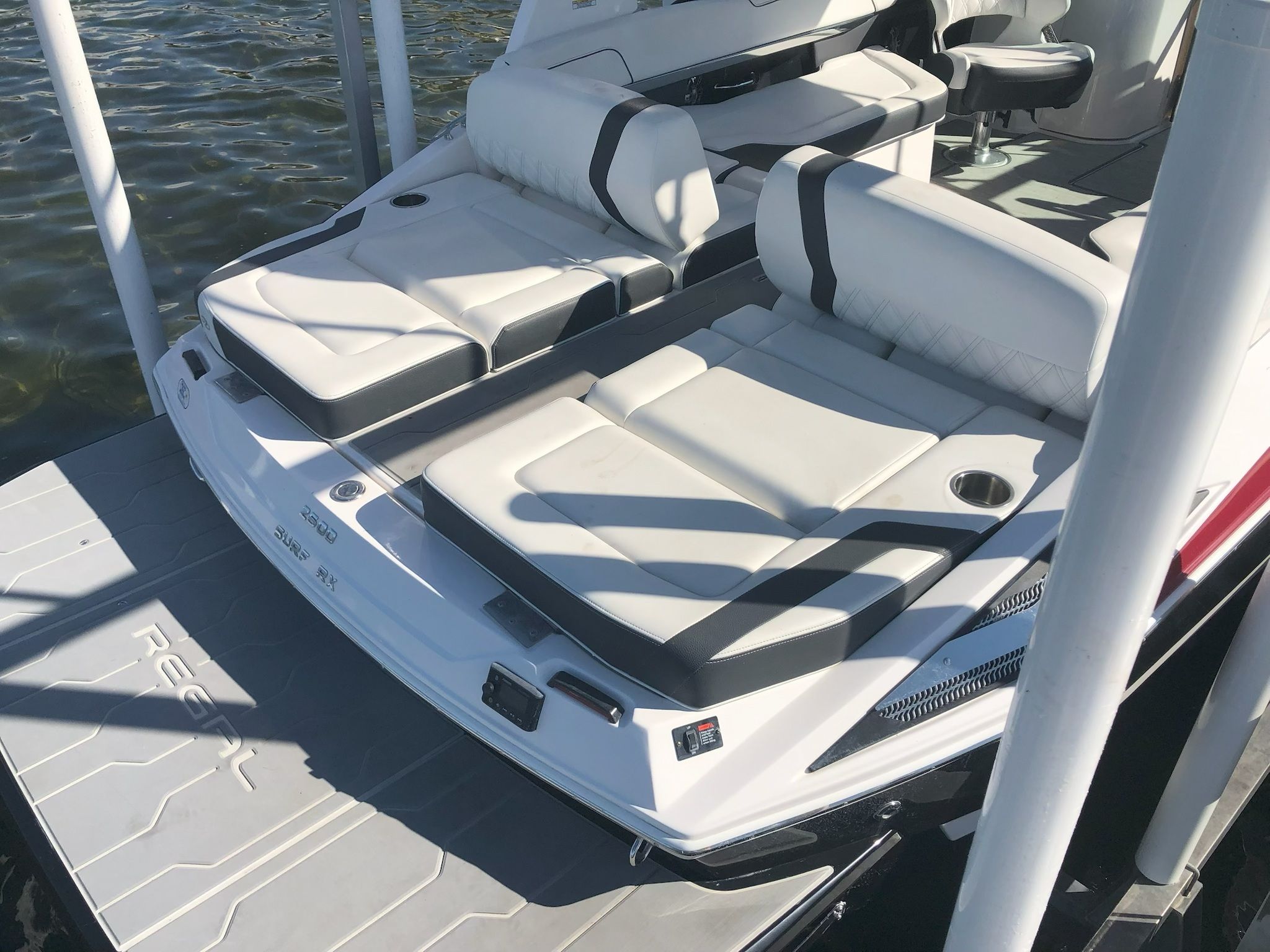 2019 Regal 25 RX Surf boat docked by water.