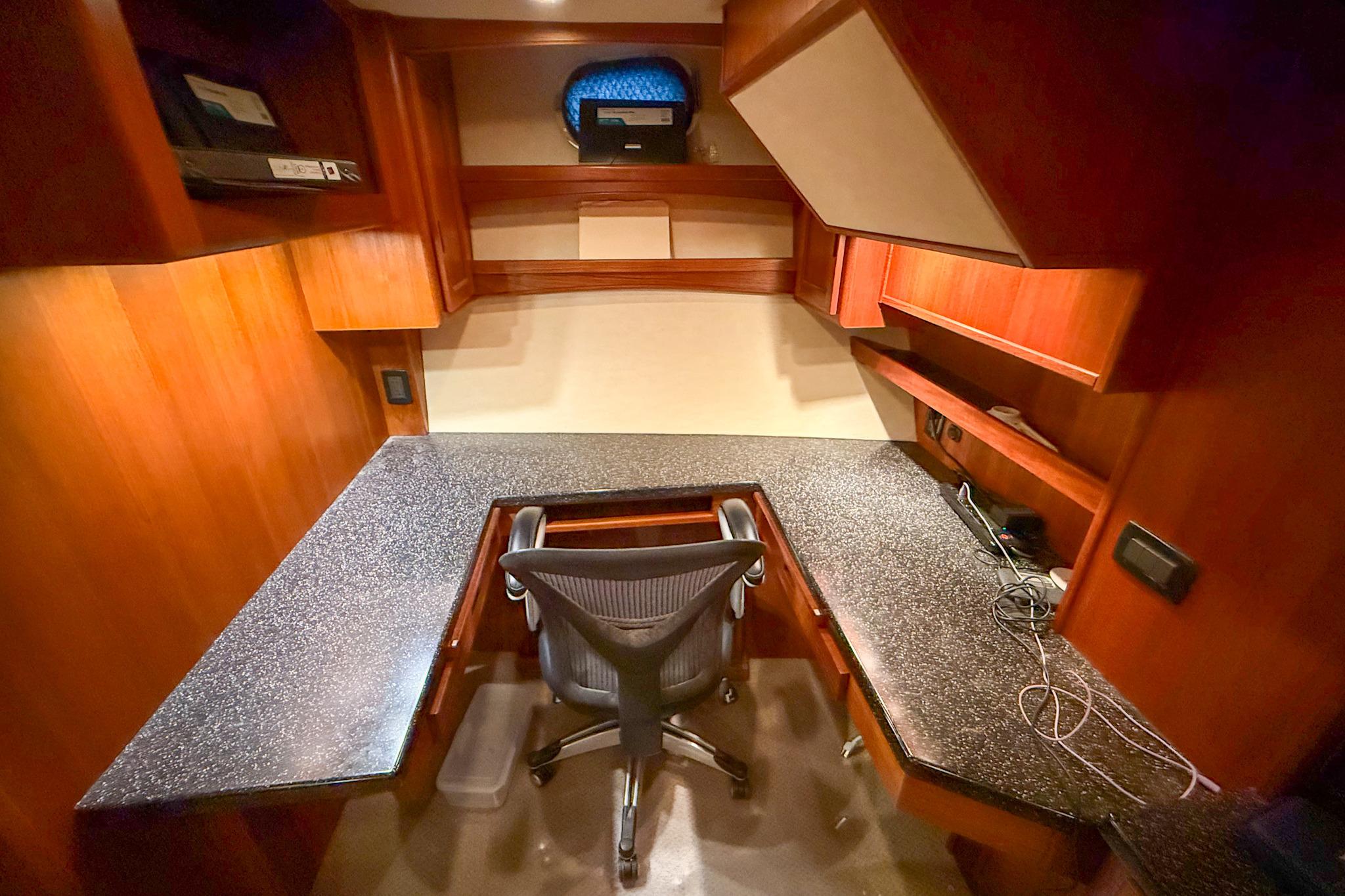 Luxurious 2007 Nordic Tug 54 yacht office with wooden cabinetry and ergonomic chair.
