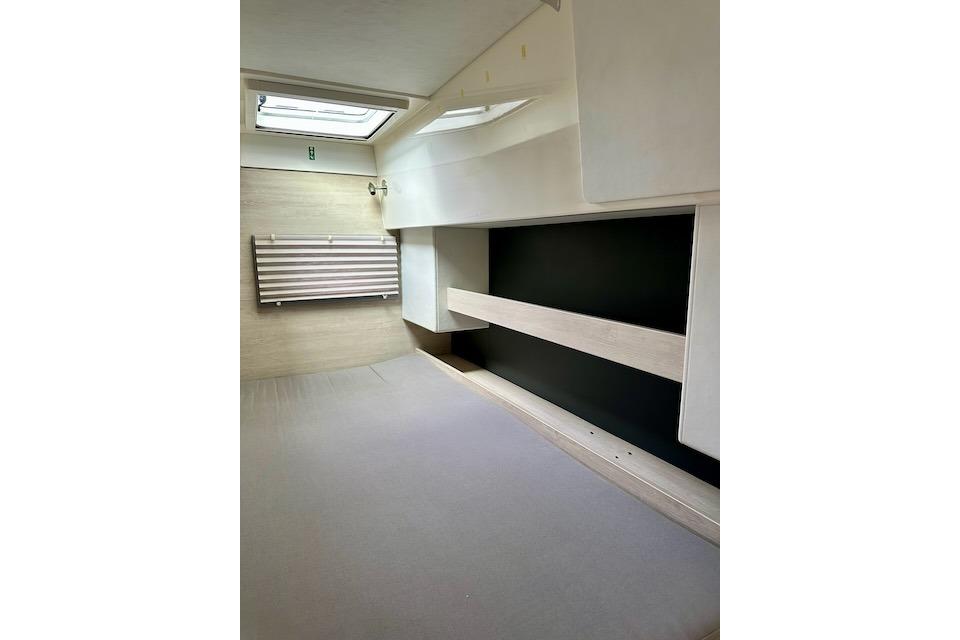 Interior cabin of a 2017 Leopard 40 catamaran, featuring a bed and storage shelves.