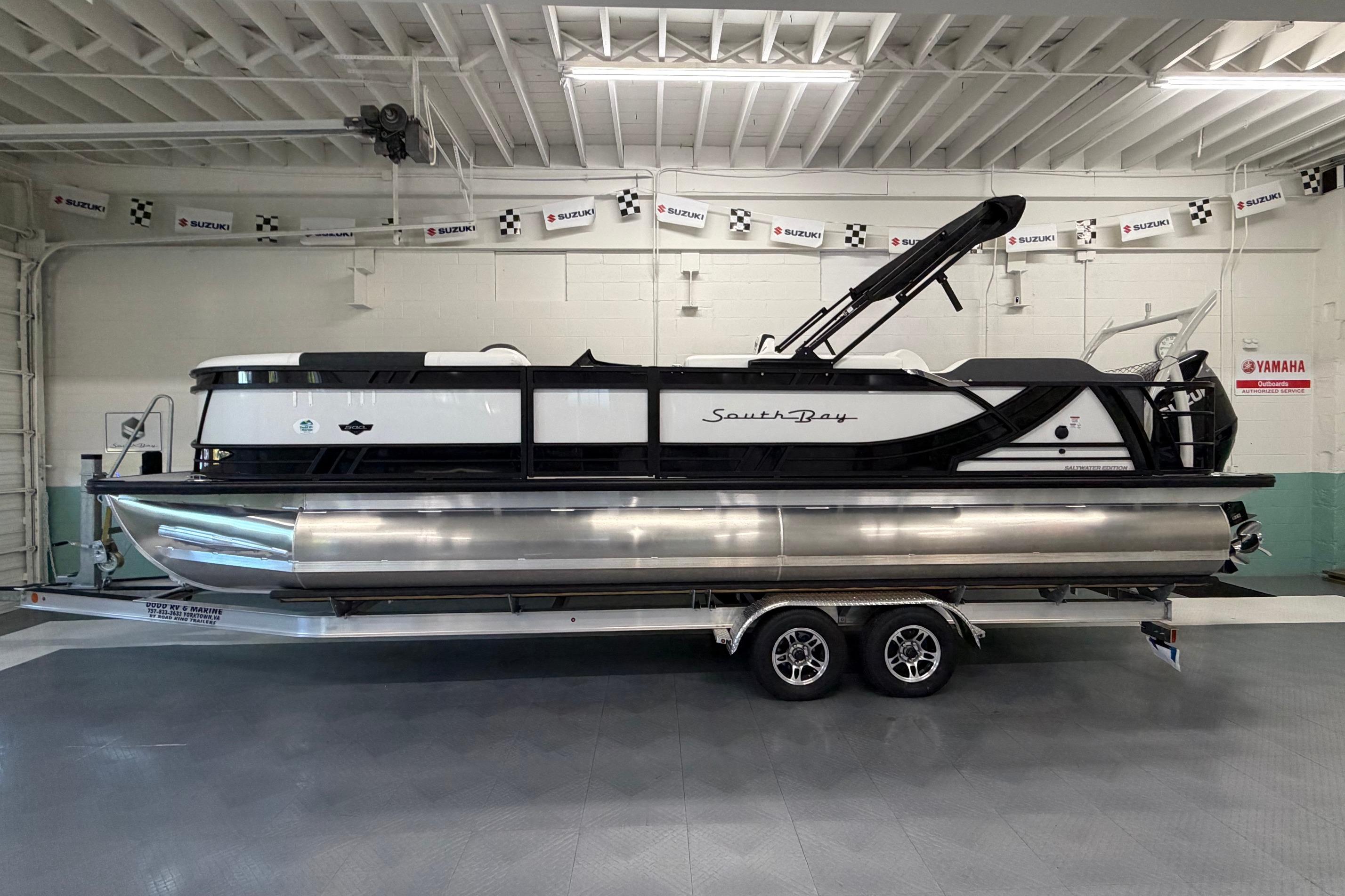 2026 South Bay 525SB2 pontoon boat on trailer in showroom setting.